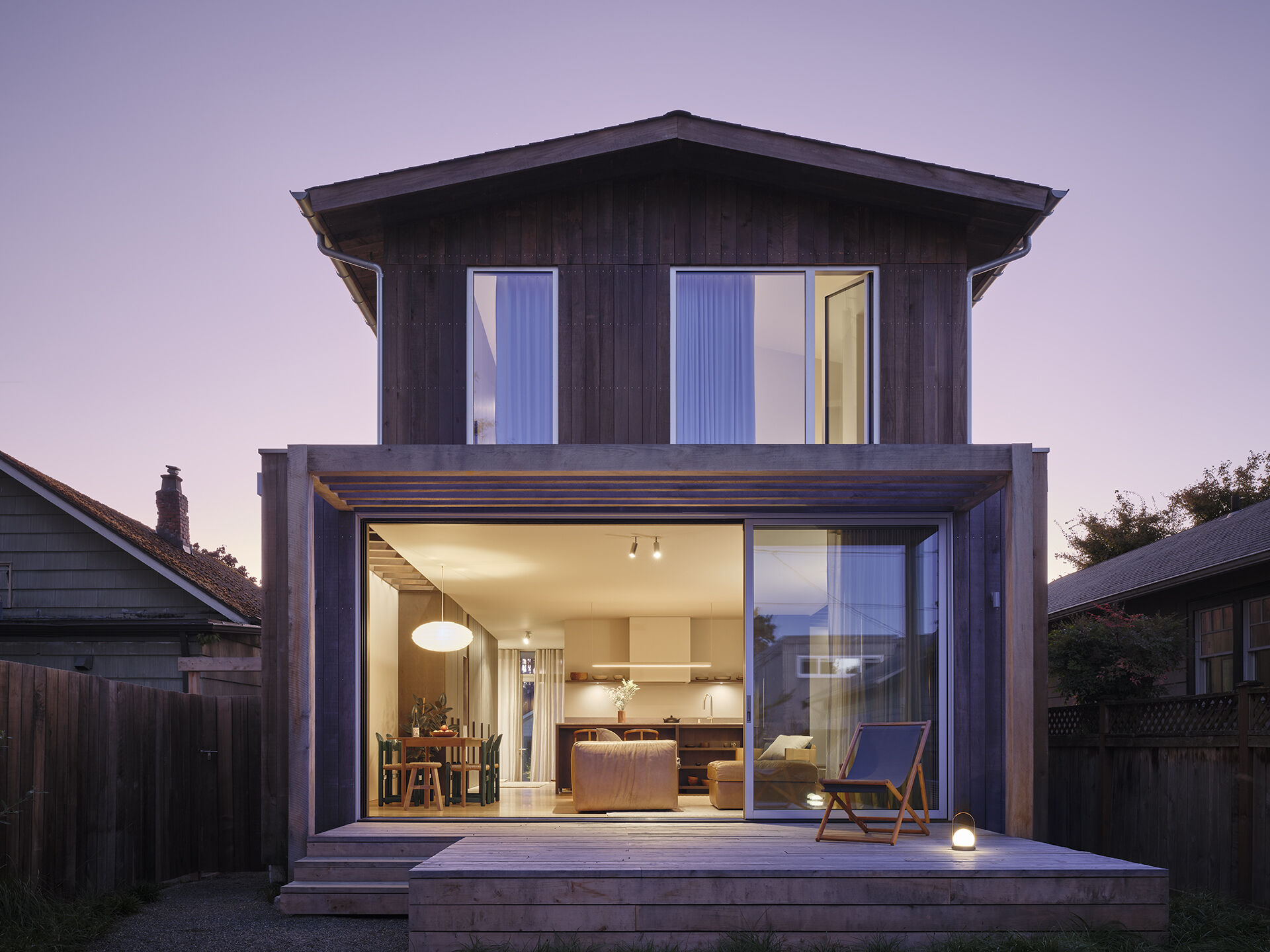 A garden-facing deck extends the living and dining areas, bringing indoor and outdoor spaces together.