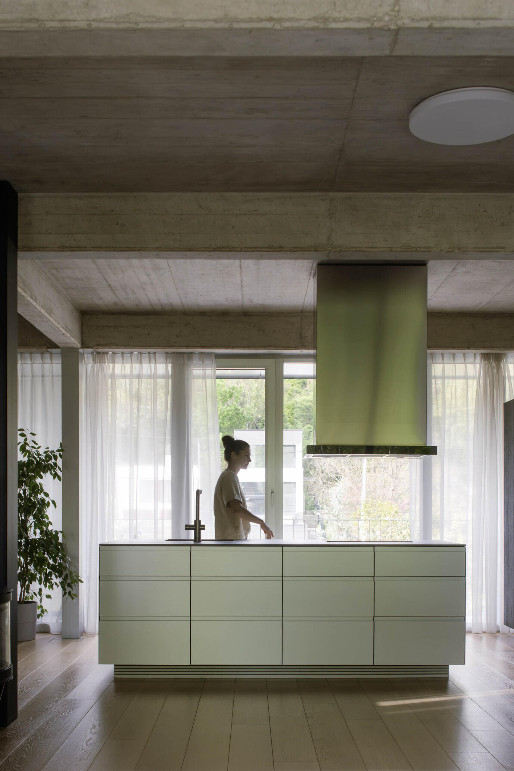 Set between the Carpathian foothills and the Danube River, this modern house features elevated living spaces, flexible interiors, panoramic views, a rooftop terrace, and a reflective raw aluminum facade that changes with the light throughout the day.
