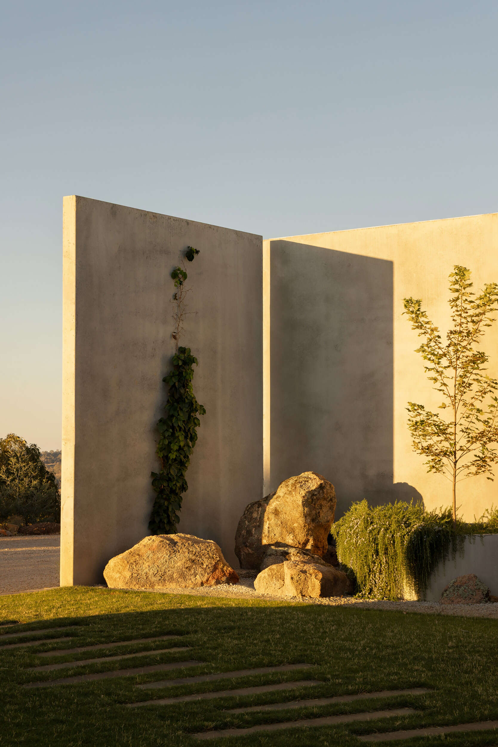 Informal plantings, large boulders, an outdoor fireplace, and a BBQ area transform the central courtyard into an inviting outdoor living space.