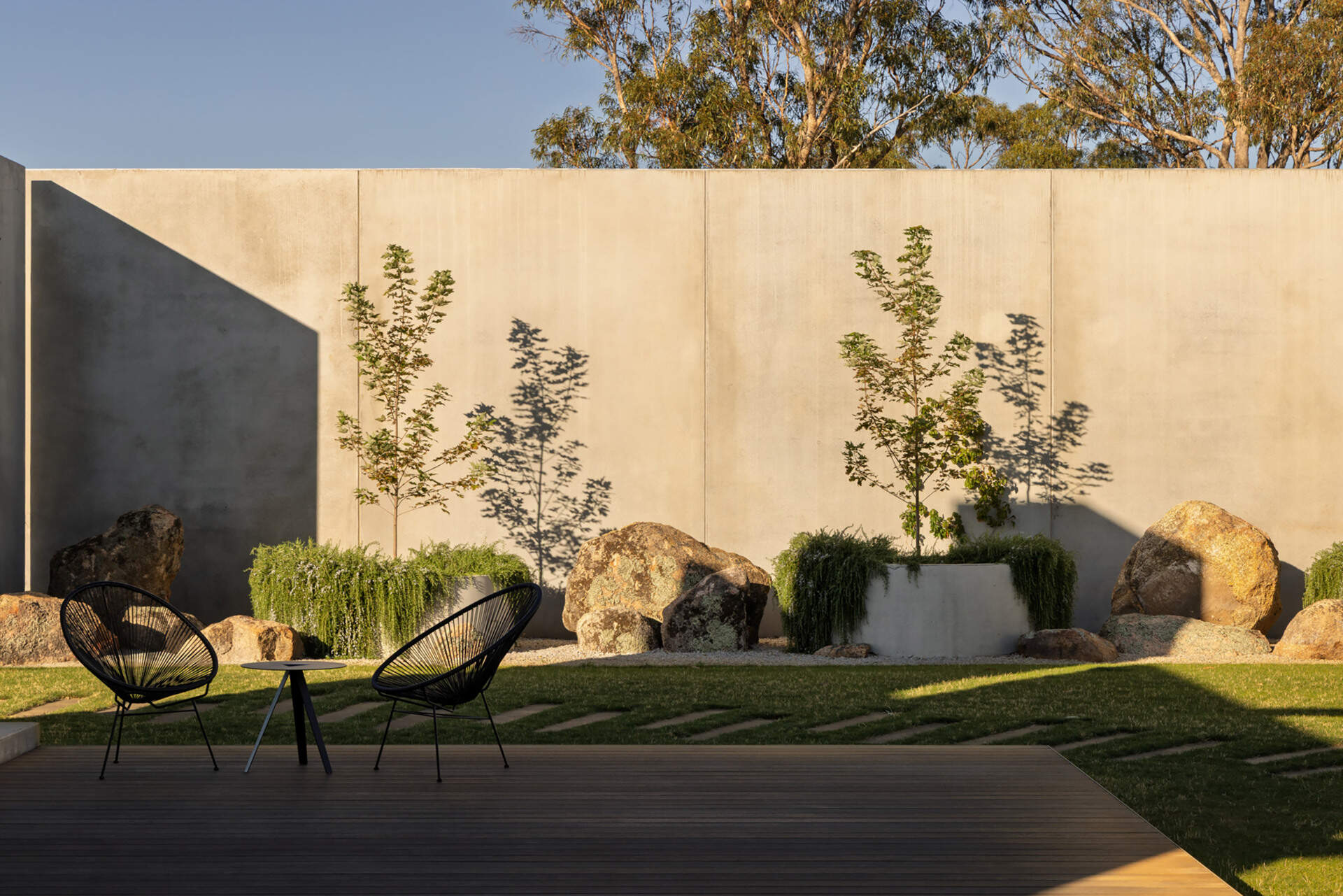 Informal plantings, large boulders, an outdoor fireplace, and a BBQ area transform the central courtyard into an inviting outdoor living space.
