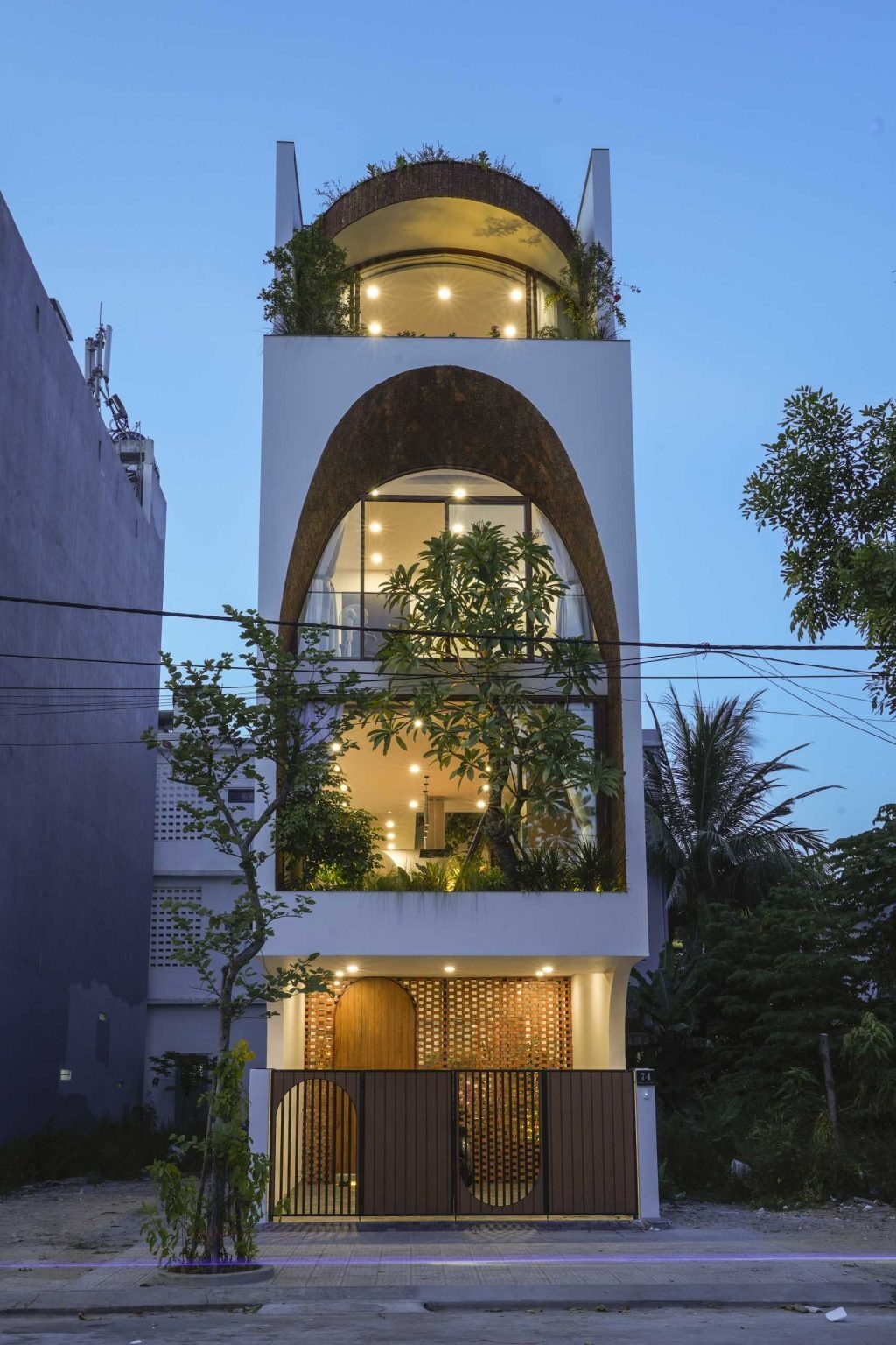 The ground floor combines built-in planters, a sitting area, and natural light to create an inviting entrance experience inside this narrow urban home.