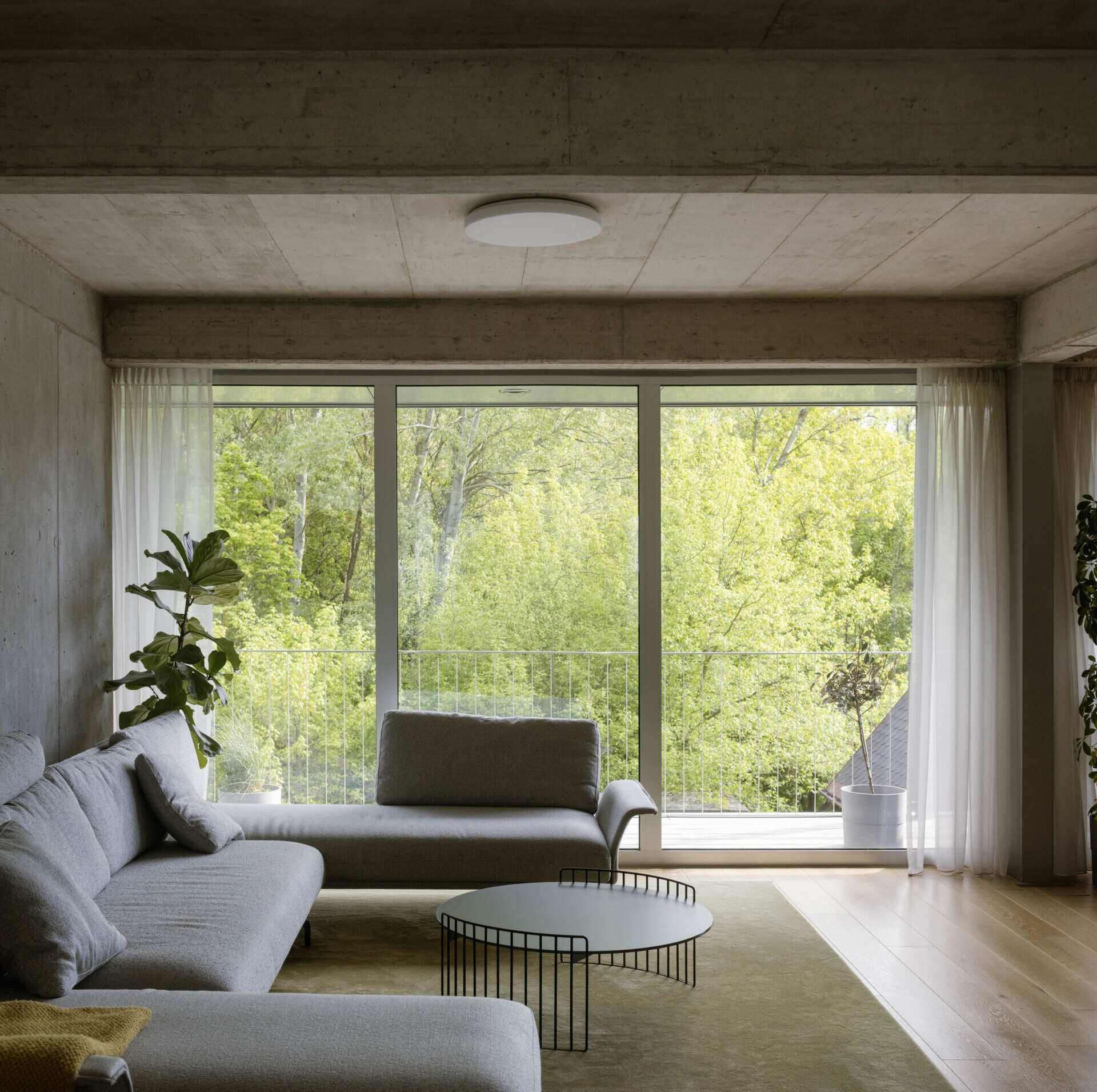 Set between the Carpathian foothills and the Danube River, this modern house features elevated living spaces, flexible interiors, panoramic views, a rooftop terrace, and a reflective raw aluminum facade that changes with the light throughout the day.