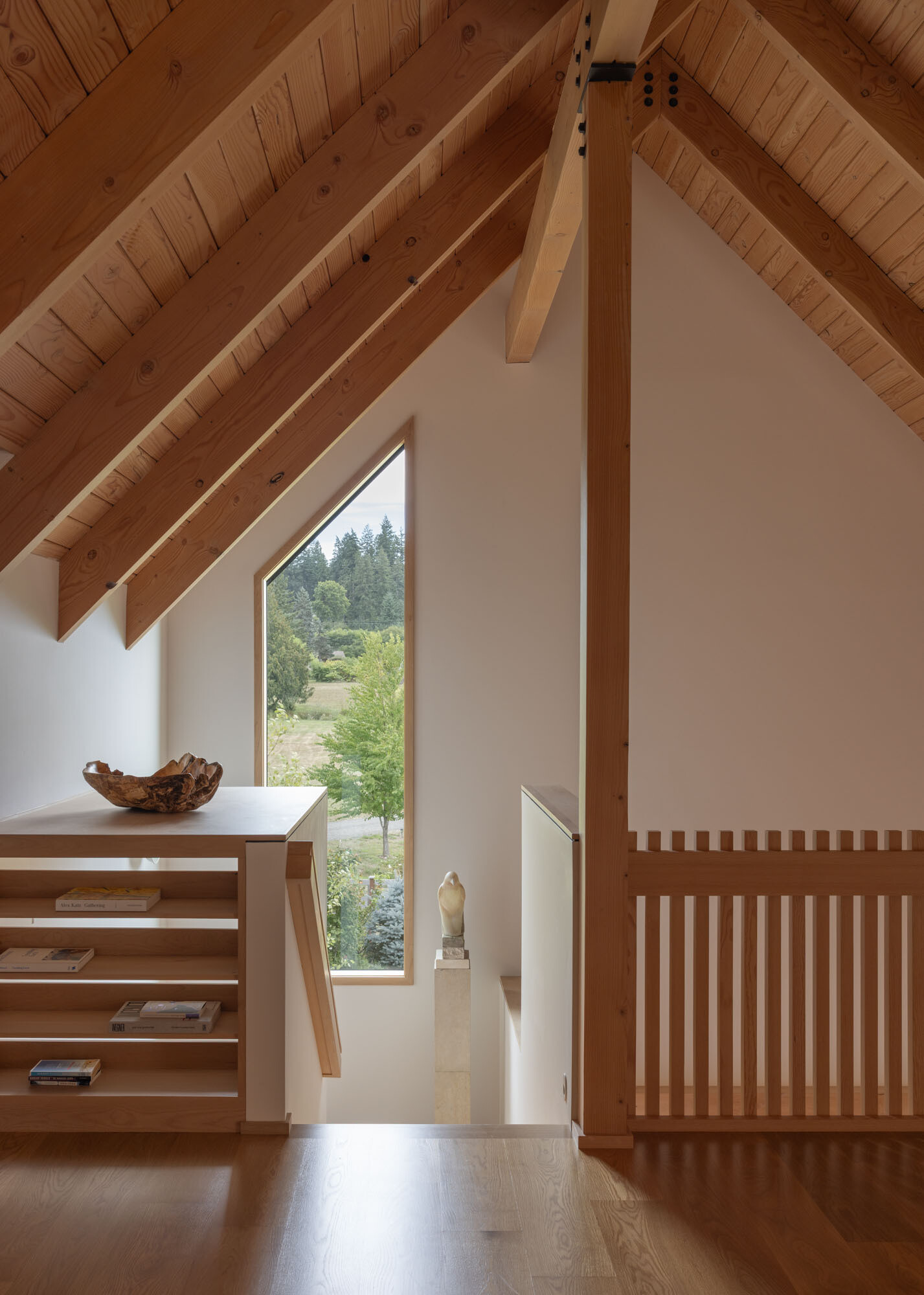 An elevated loft provides flexible office and storage space while overlooking the home's dramatic interior volumes.