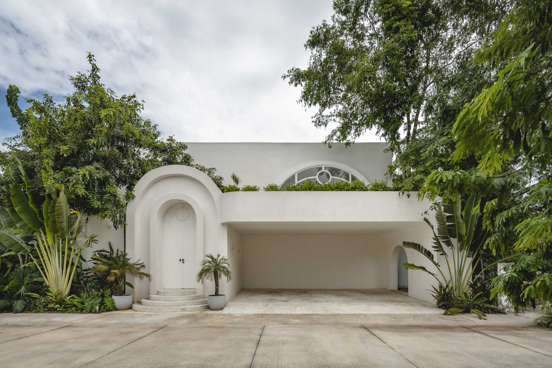 Eclipse House in Mérida, Mexico, is a striking exploration of geometry, light, and landscape. Designed by Etea and Ghostframe, the home features a dramatic double-height gallery, arch-lined walkways, circular openings that inspired its name, and lush gardens woven throughout the architecture.