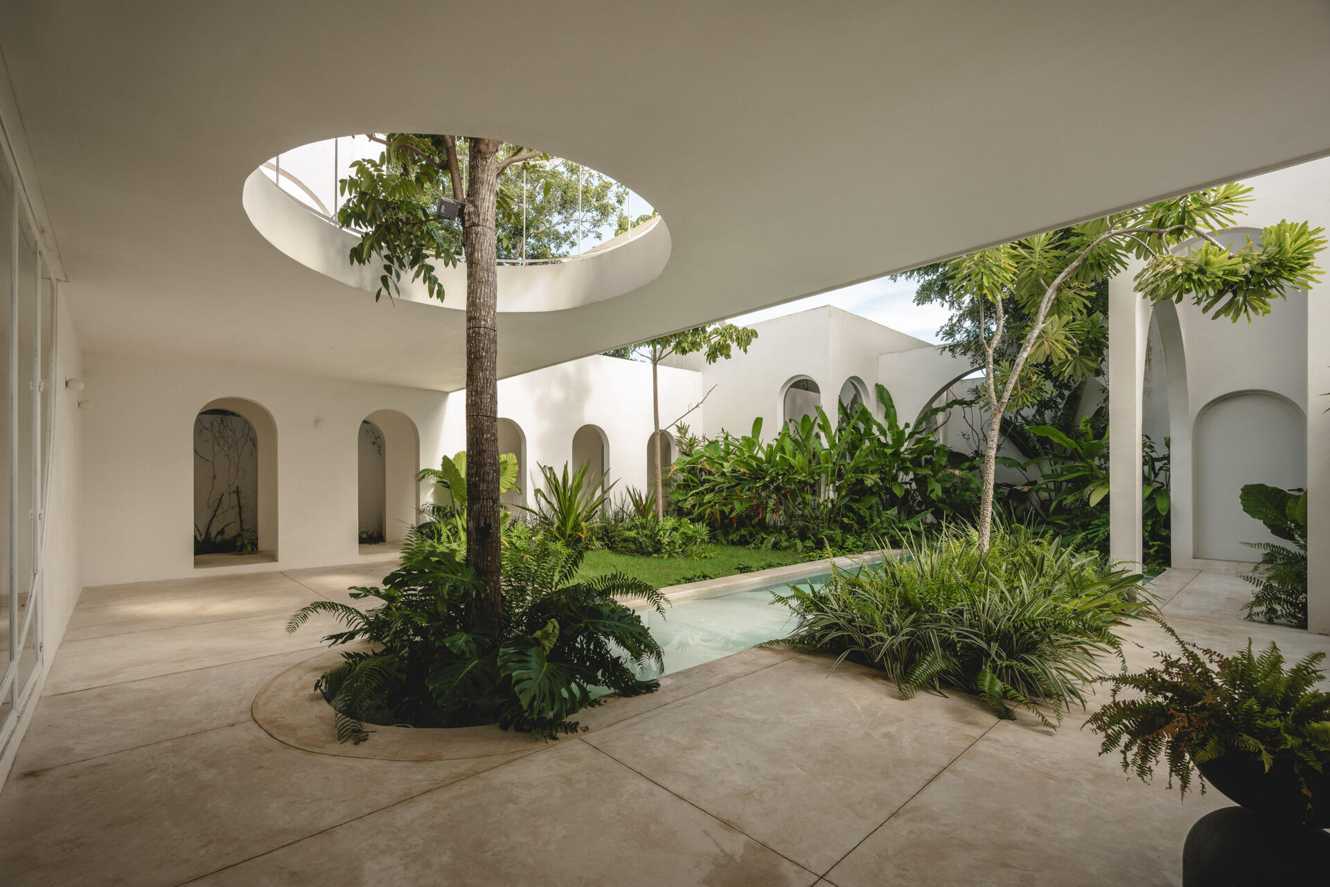 Eclipse House in Mérida, Mexico, is a striking exploration of geometry, light, and landscape. Designed by Etea and Ghostframe, the home features a dramatic double-height gallery, arch-lined walkways, circular openings that inspired its name, and lush gardens woven throughout the architecture.