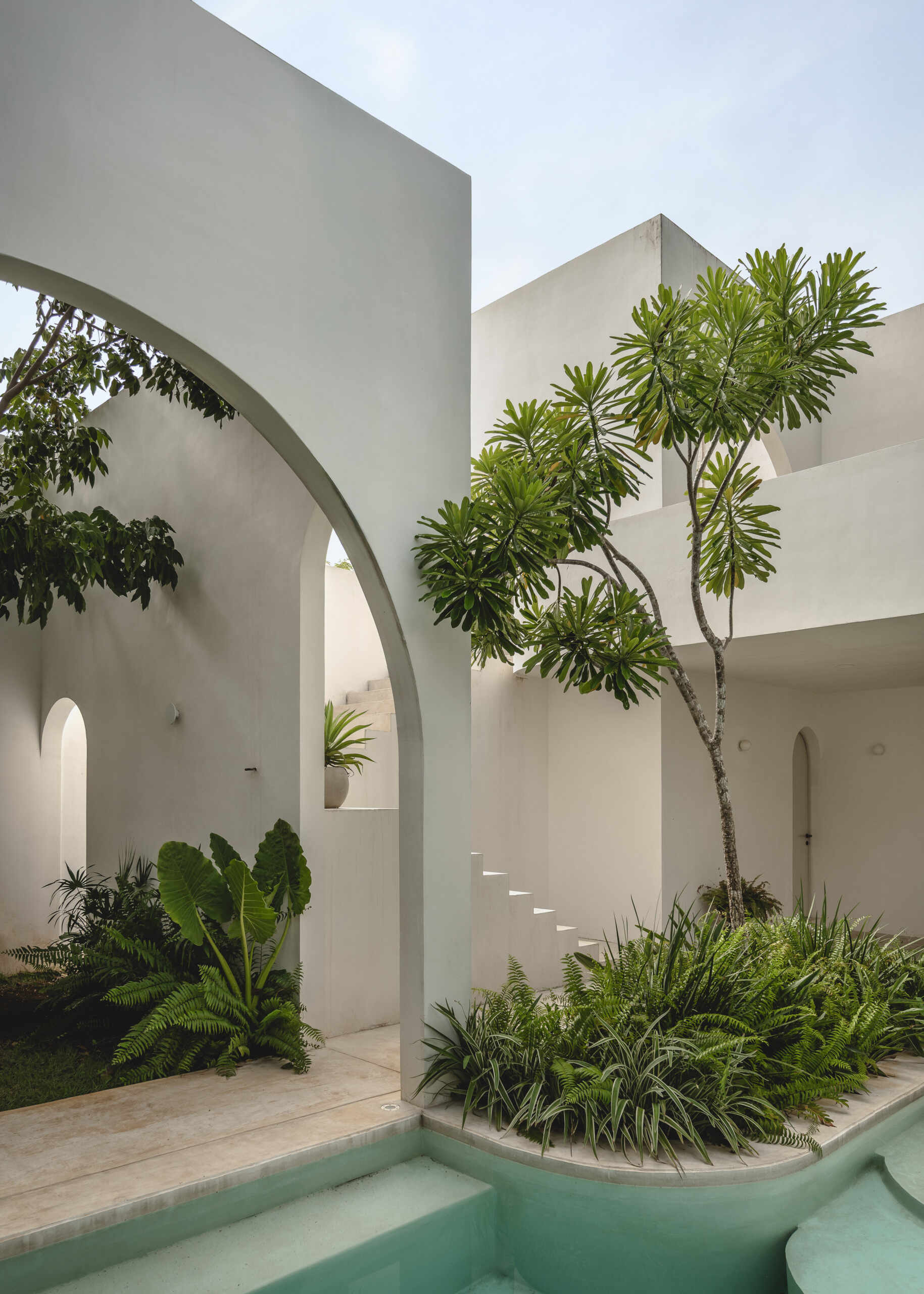 Eclipse House in Mérida, Mexico, is a striking exploration of geometry, light, and landscape. Designed by Etea and Ghostframe, the home features a dramatic double-height gallery, arch-lined walkways, circular openings that inspired its name, and lush gardens woven throughout the architecture.