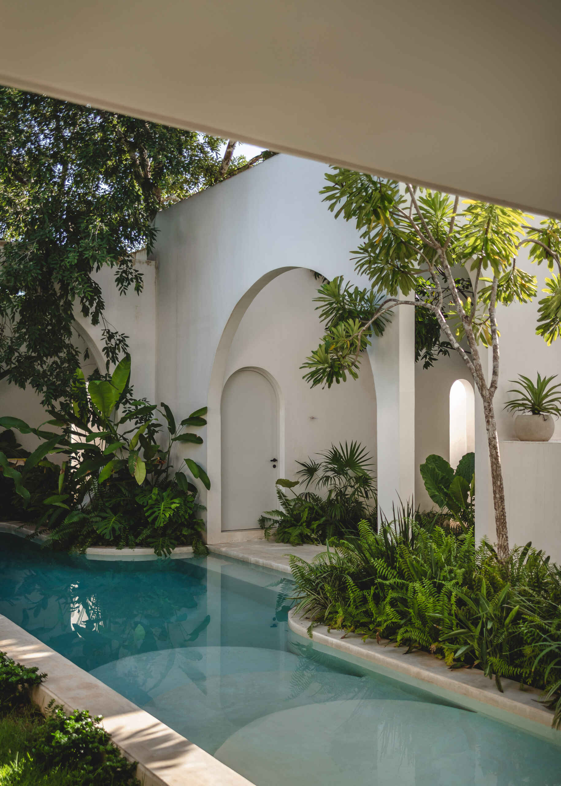 Eclipse House in Mérida, Mexico, is a striking exploration of geometry, light, and landscape. Designed by Etea and Ghostframe, the home features a dramatic double-height gallery, arch-lined walkways, circular openings that inspired its name, and lush gardens woven throughout the architecture.
