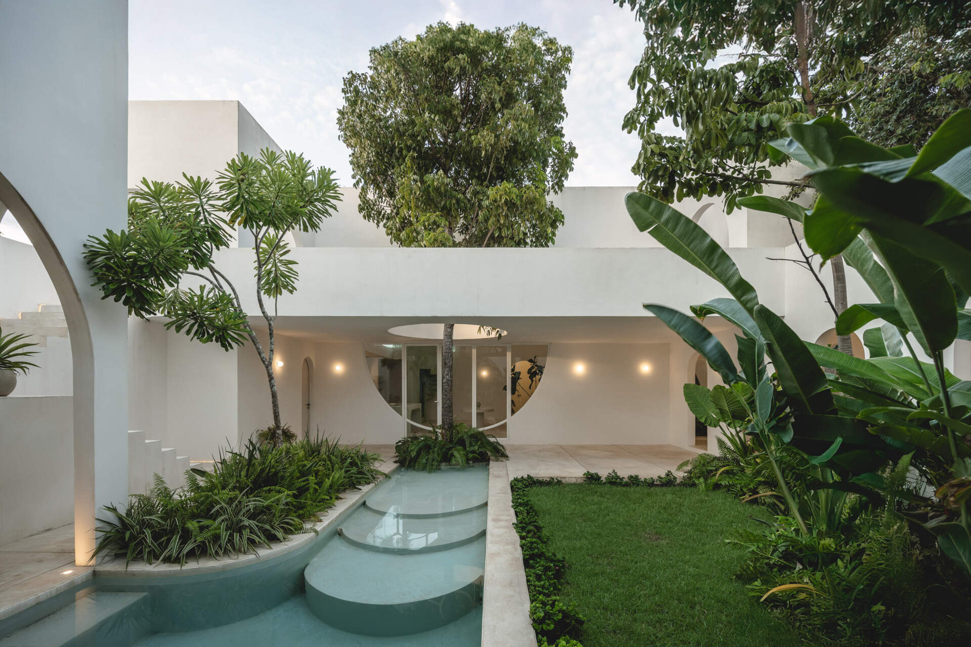 Eclipse House in Mérida, Mexico, is a striking exploration of geometry, light, and landscape. Designed by Etea and Ghostframe, the home features a dramatic double-height gallery, arch-lined walkways, circular openings that inspired its name, and lush gardens woven throughout the architecture.