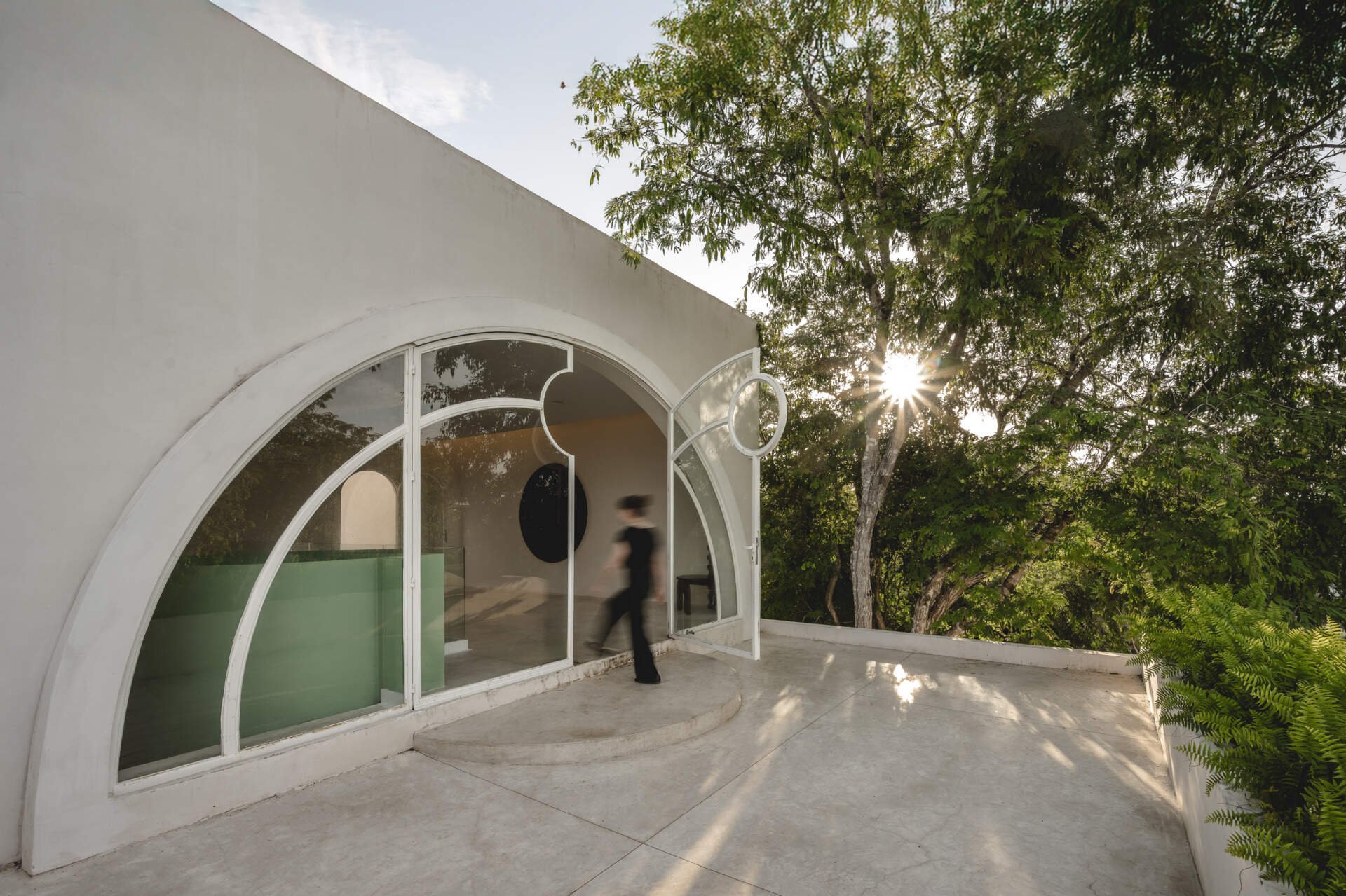 Eclipse House in Mérida, Mexico, is a striking exploration of geometry, light, and landscape. Designed by Etea and Ghostframe, the home features a dramatic double-height gallery, arch-lined walkways, circular openings that inspired its name, and lush gardens woven throughout the architecture.