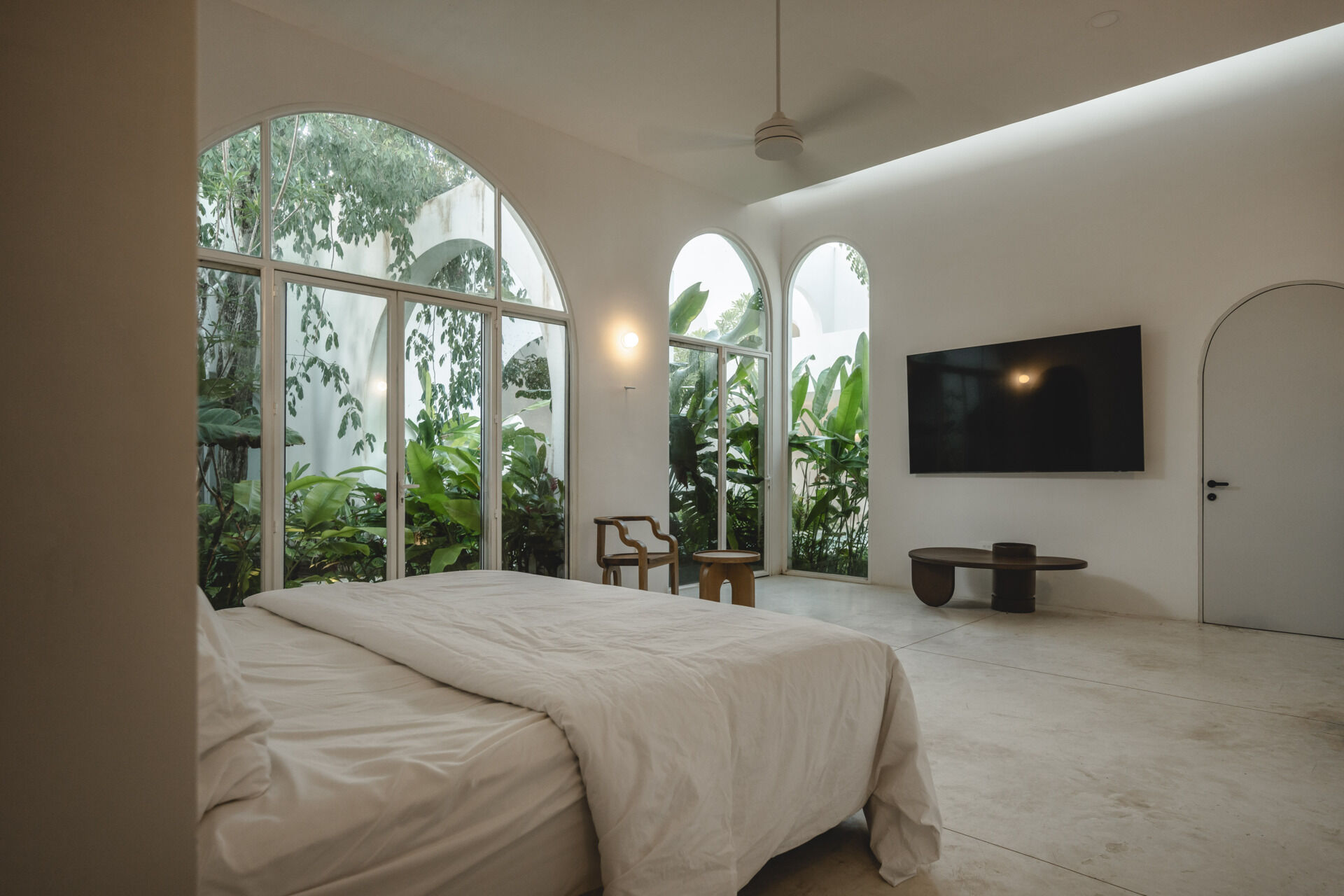 Eclipse House in Mérida, Mexico, is a striking exploration of geometry, light, and landscape. Designed by Etea and Ghostframe, the home features a dramatic double-height gallery, arch-lined walkways, circular openings that inspired its name, and lush gardens woven throughout the architecture.