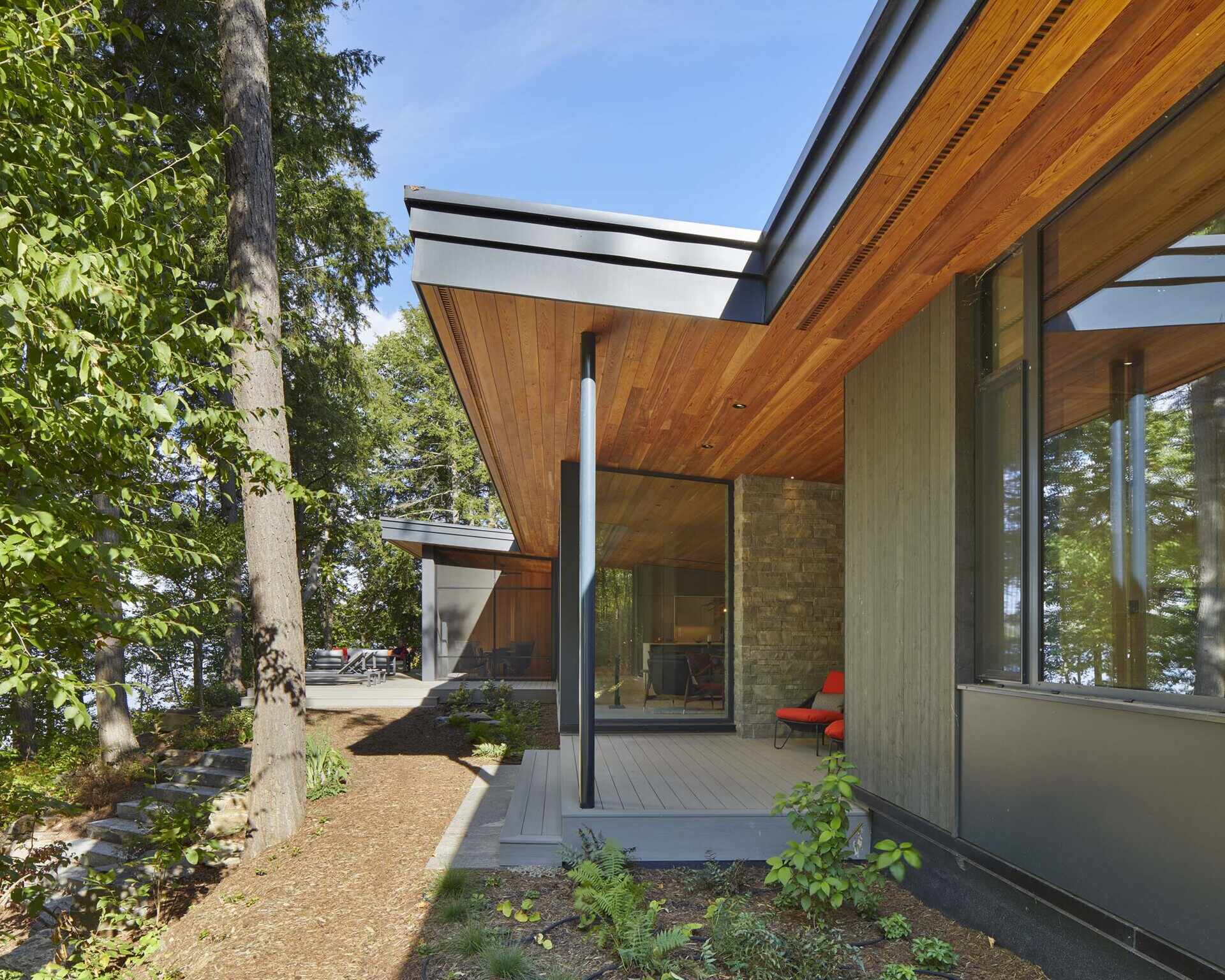 Generous roof overhangs extend outward from the central volume, forming an additional outdoor area, and helping separate the primary suite from the rest of the home.