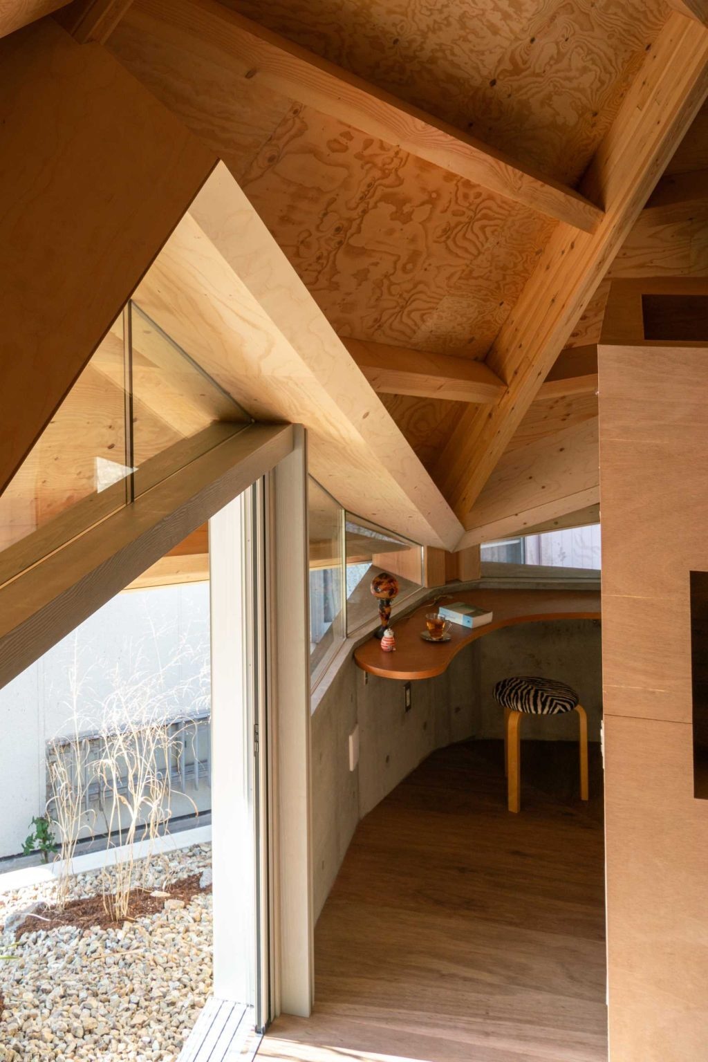 Built-in desks, raised platforms, and custom features help define activity zones inside this open Japanese home without disrupting its spacious layout.
