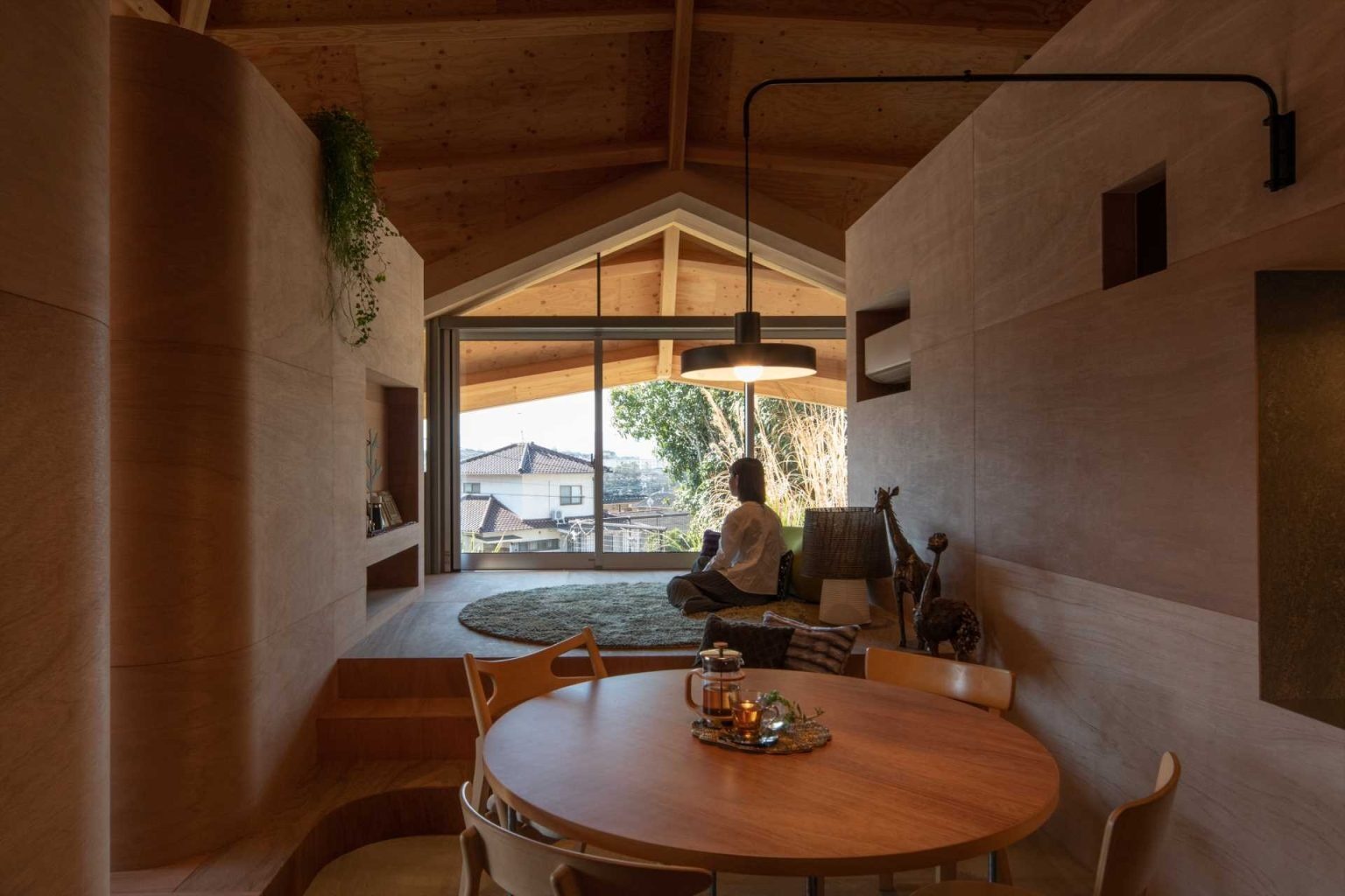 The dining room sits beneath the center of the spiderweb structure, creating a dramatic focal point enhanced by curved architectural details and striking roof geometry.