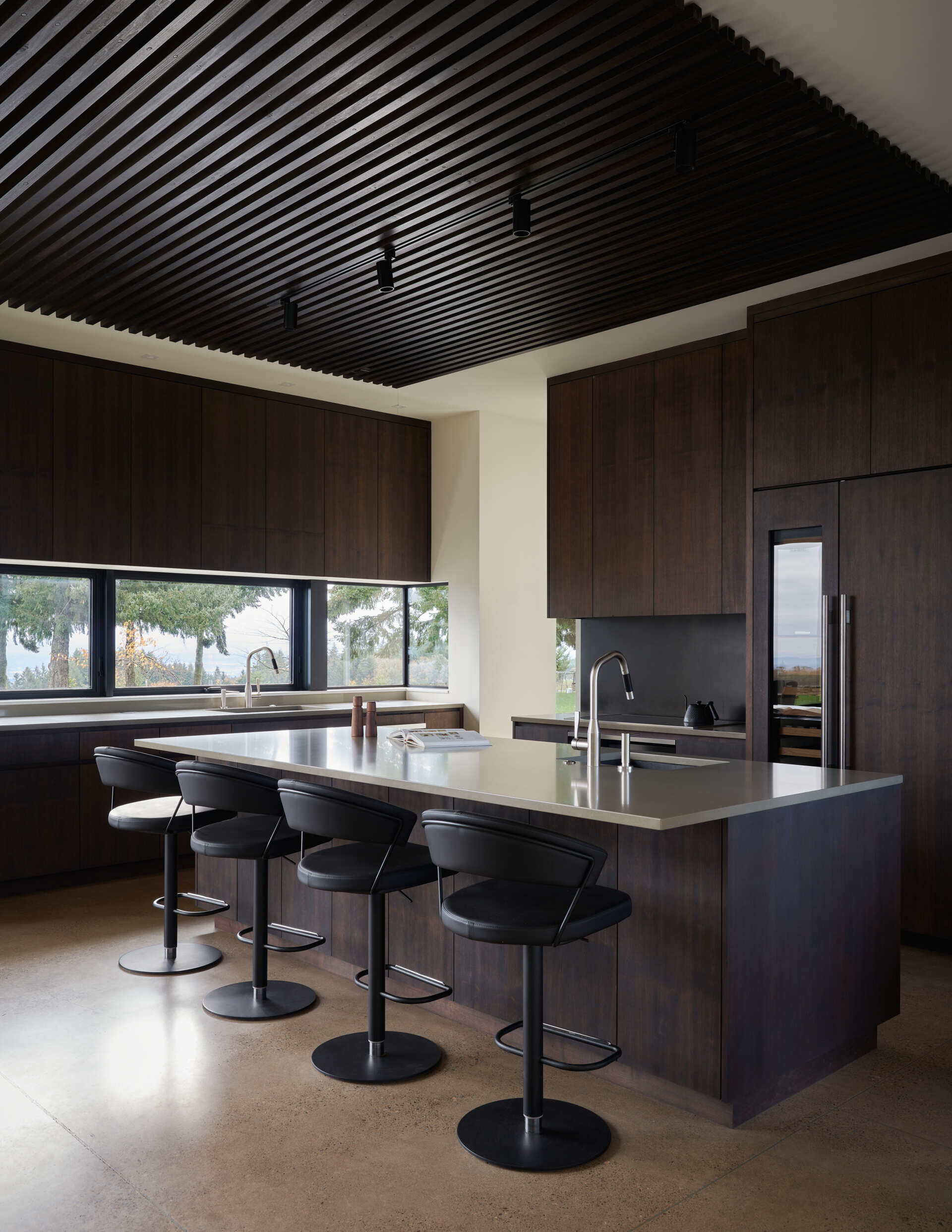 A modern kitchen with dark wood cabinets and an island.