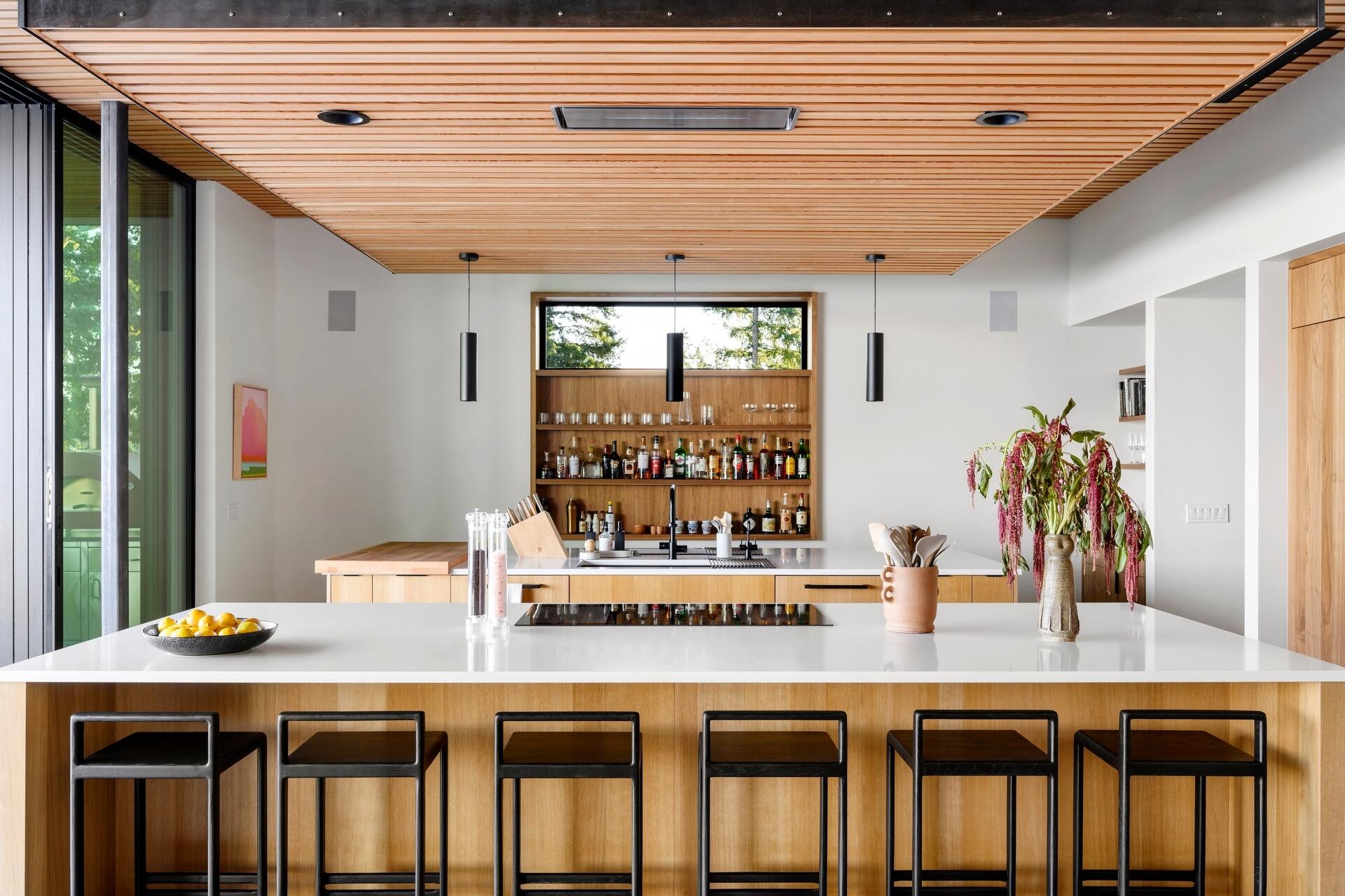 Explore the modern double-island kitchen at Lantern House, where warm timber finishes, minimalist design, and seamless indoor-outdoor living create the perfect entertaining space.