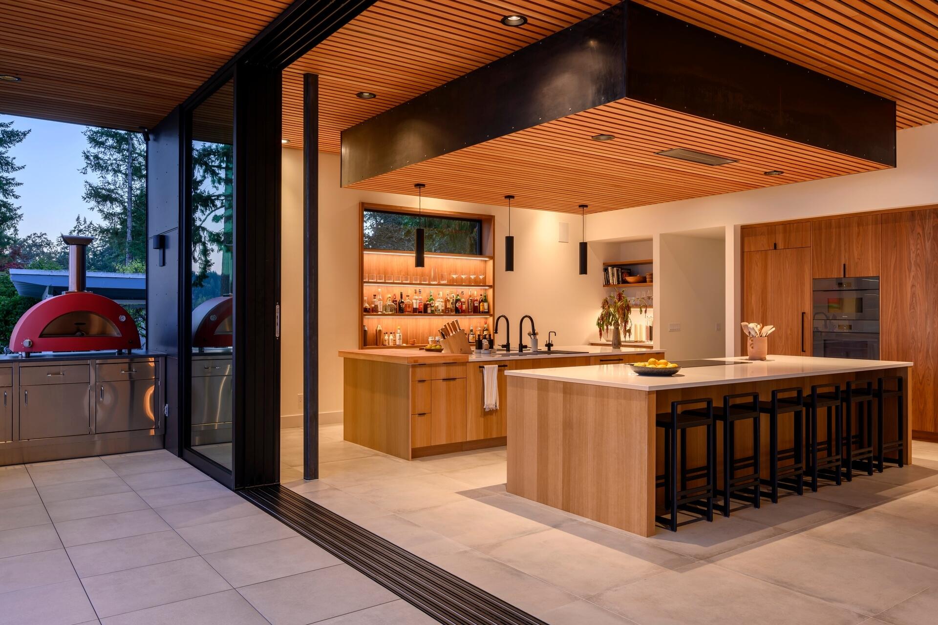 Explore the modern double-island kitchen at Lantern House, where warm timber finishes, minimalist design, and seamless indoor-outdoor living create the perfect entertaining space.