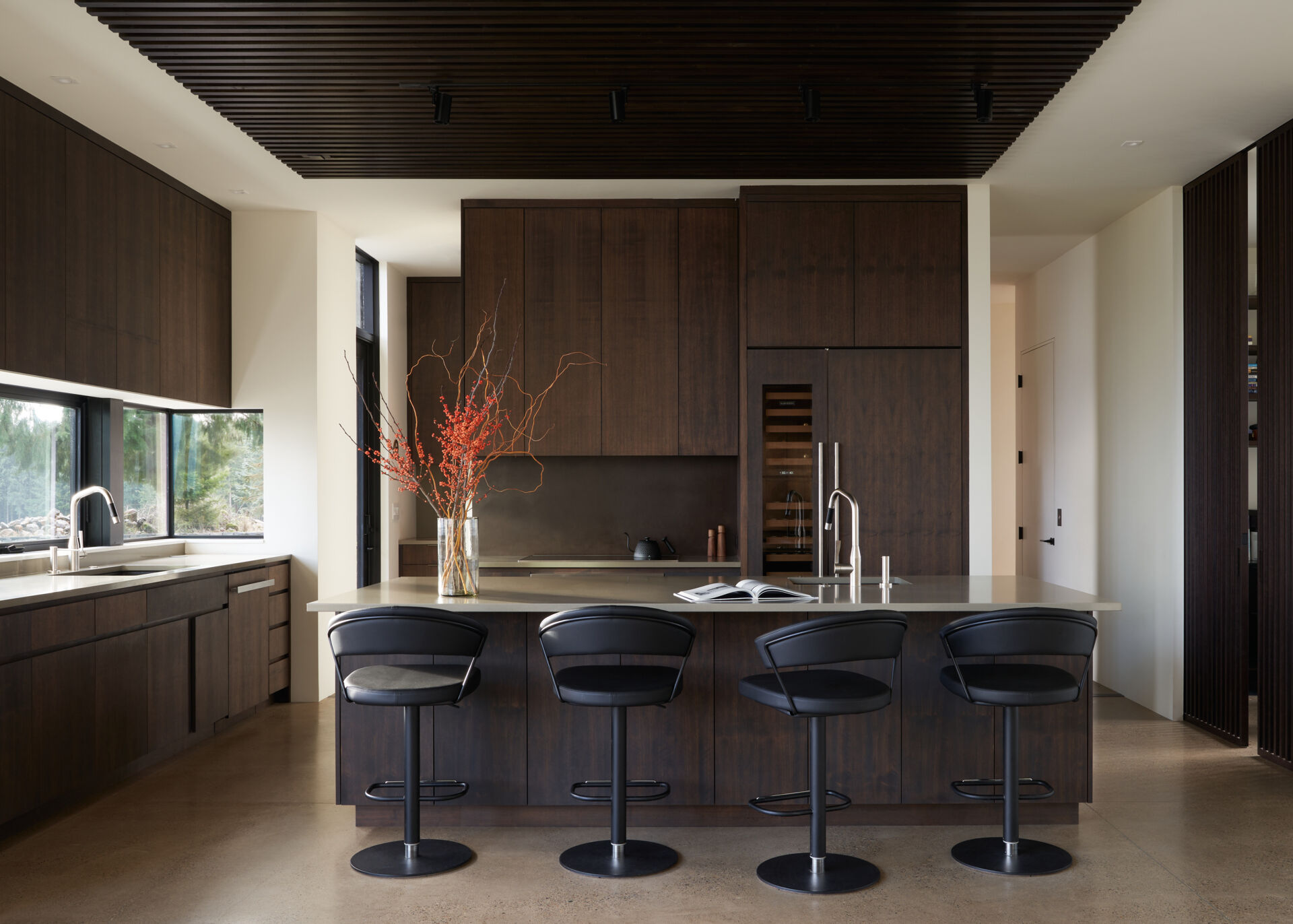 A modern kitchen with dark wood cabinets and an island.