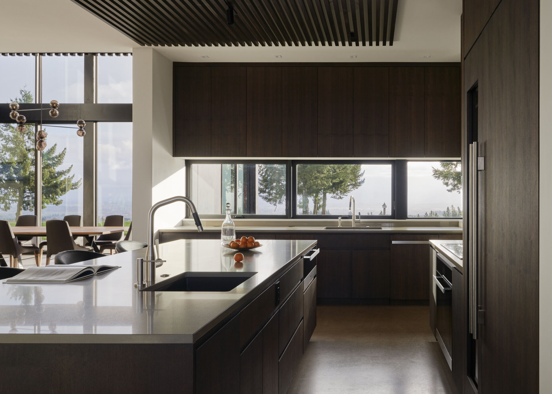 A modern kitchen with dark wood cabinets and an island.