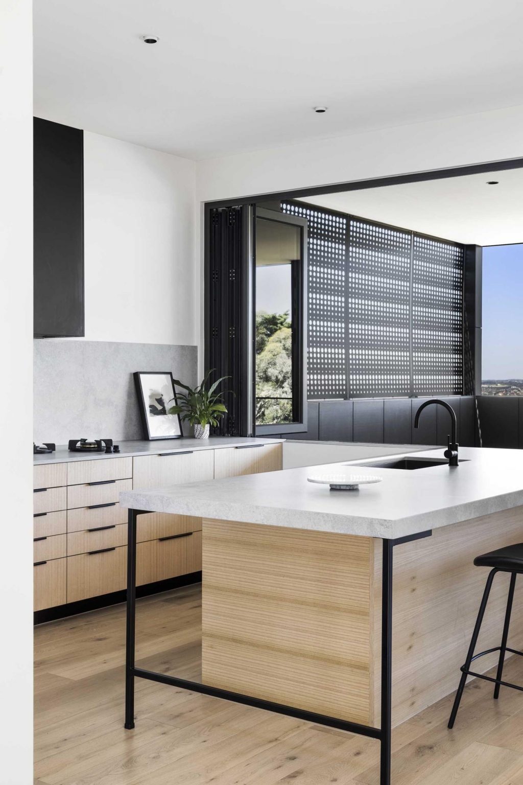 Black cabinetry and white Ash timber veneers give this minimalist kitchen a refined look that feels warm and contemporary.