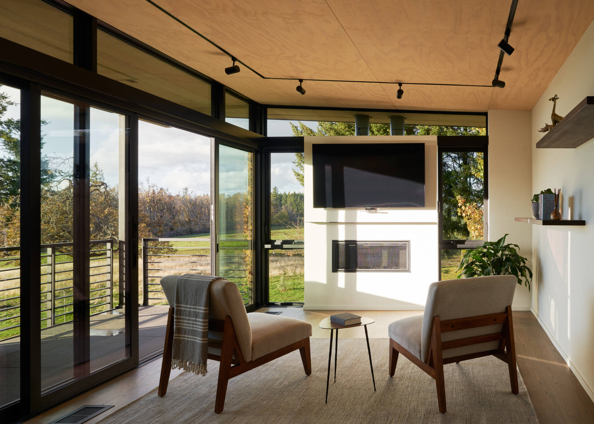 A modern sitting area with a fireplace and sliding glass doors that open to a balcony.