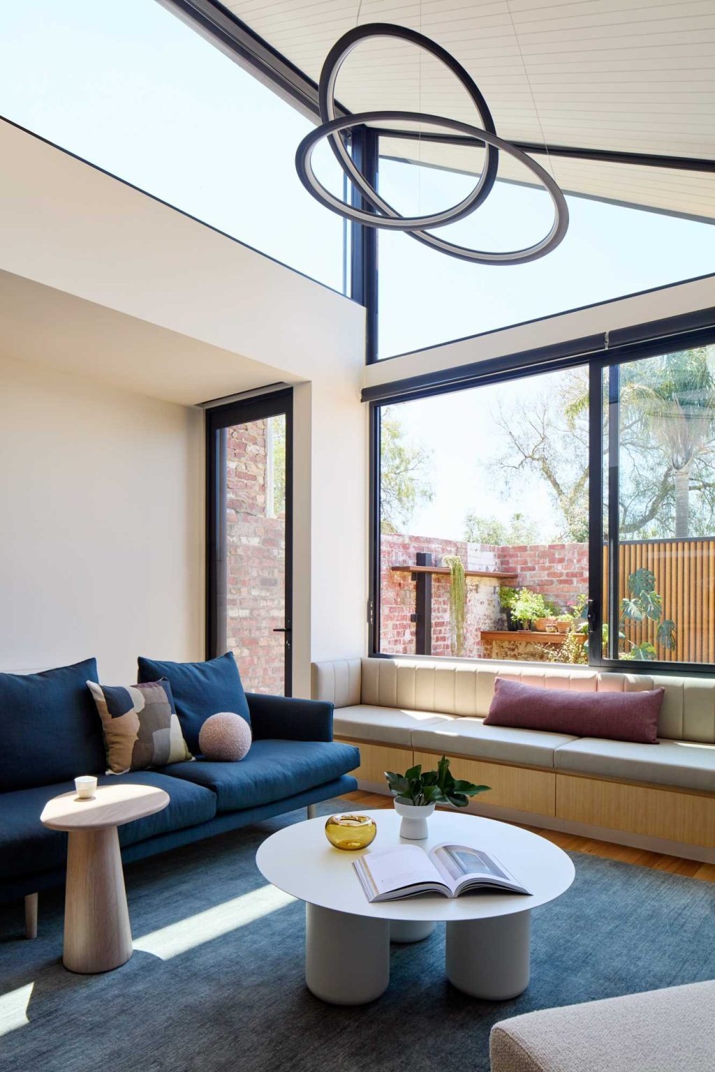 Custom built-in seating, warm timber finishes and light-filled interiors make this living room a standout feature of the Victorian terrace extension.