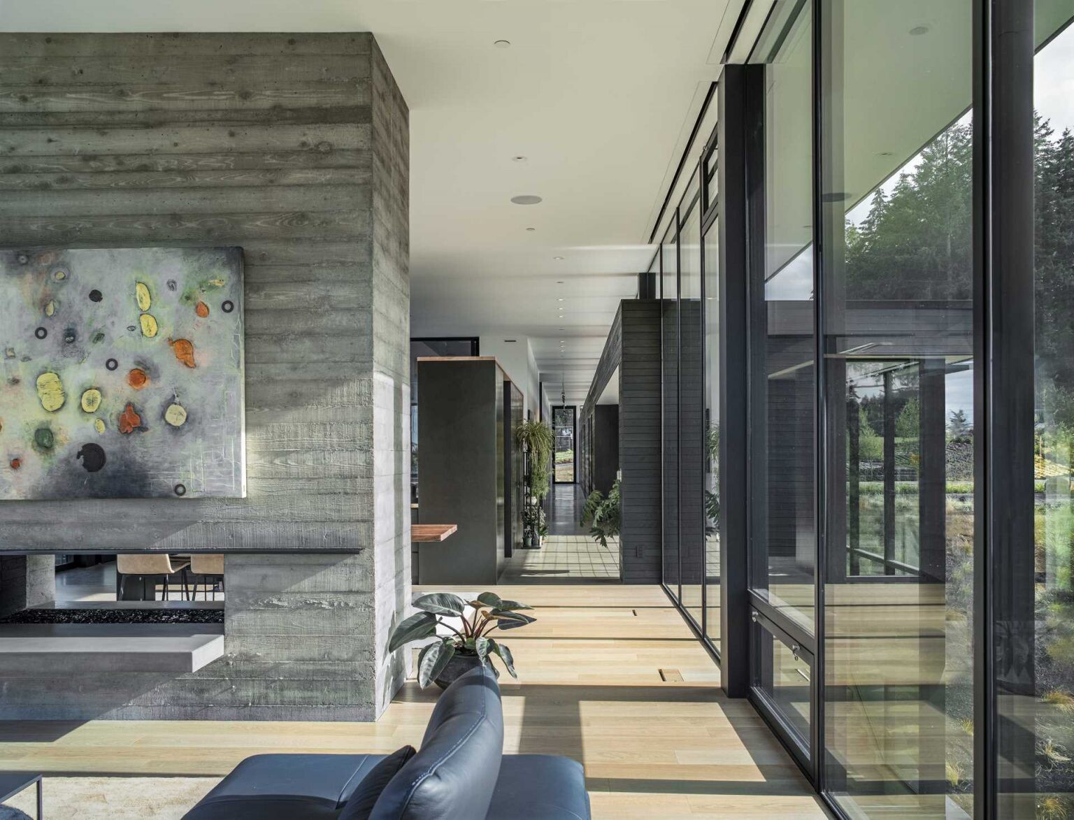 This board-formed concrete fireplace anchors the home both visually and structurally while serving the living and dining spaces.