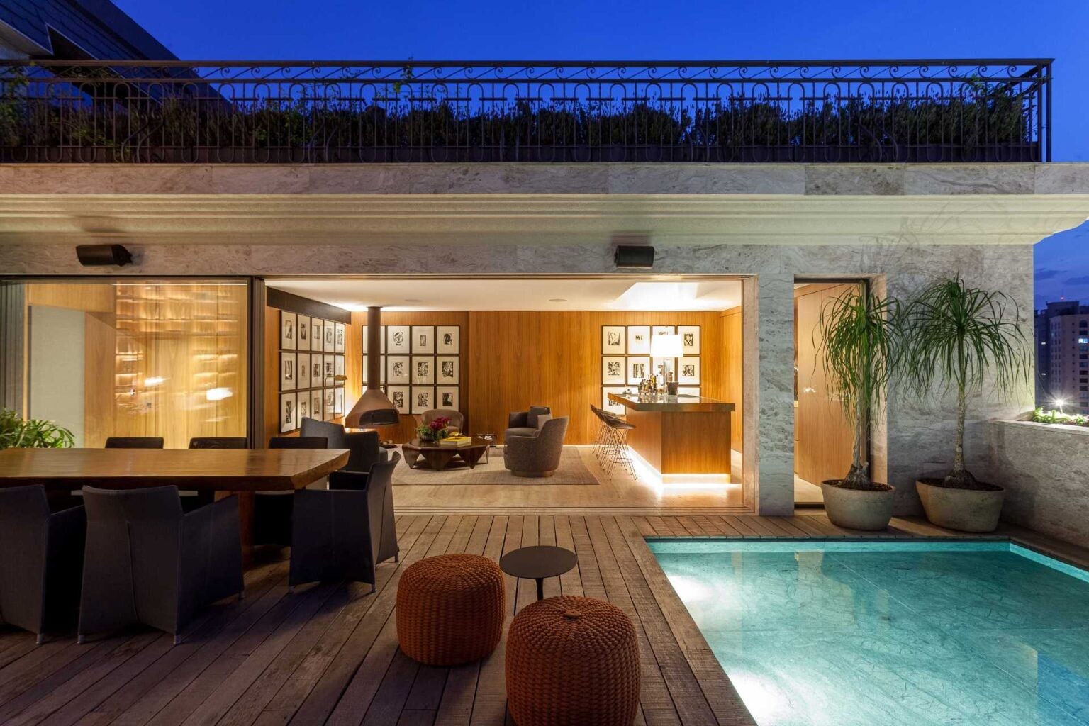 This luxury penthouse terrace combines a pool, lounge, outdoor dining, and panoramic city views. Connected to an entertainment room with a fireplace and bar, it's designed for effortless indoor-outdoor living.