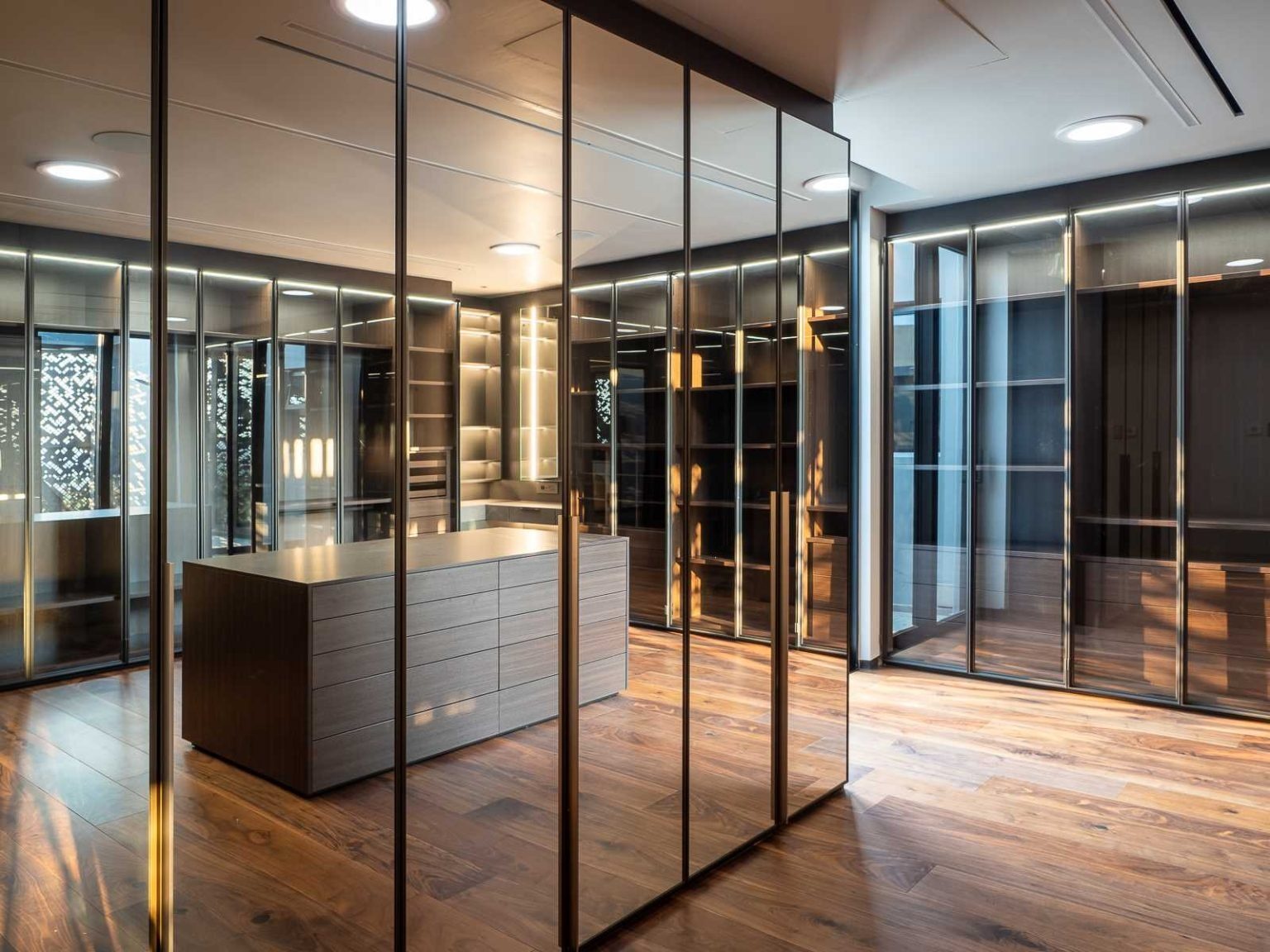Mirrored surfaces and extensive closet space define this spacious dressing room, combining luxury with everyday practicality.