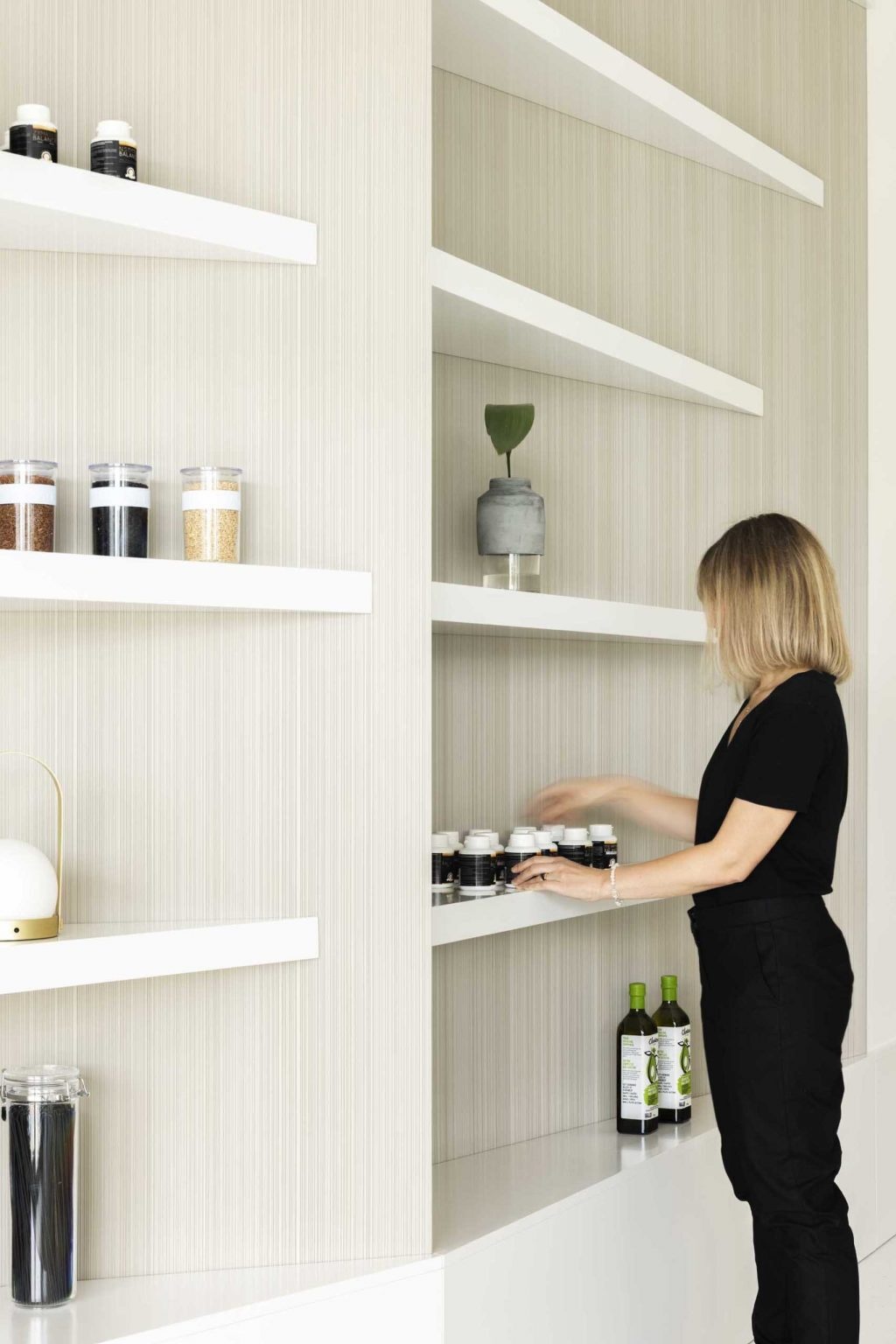 Triangular white shelving transforms an ordinary wall into an architectural statement, adding sculptural interest to this minimalist clinic interior.