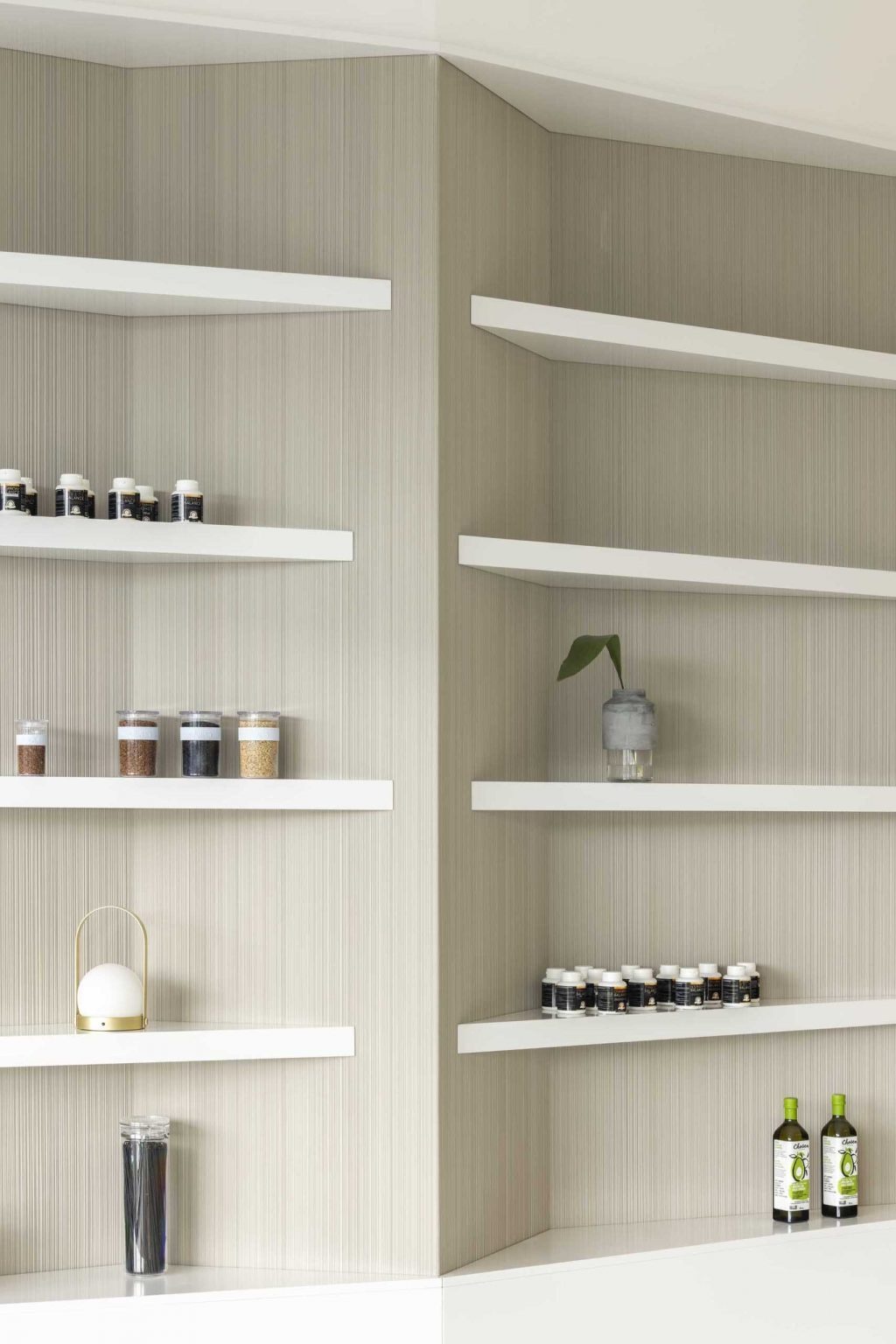 Triangular white shelving transforms an ordinary wall into an architectural statement, adding sculptural interest to this minimalist clinic interior.