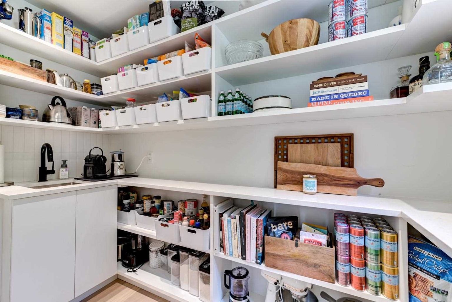 A spacious walk-in pantry with built-in storage keeps the kitchen organized while supporting the home's minimalist aesthetic.