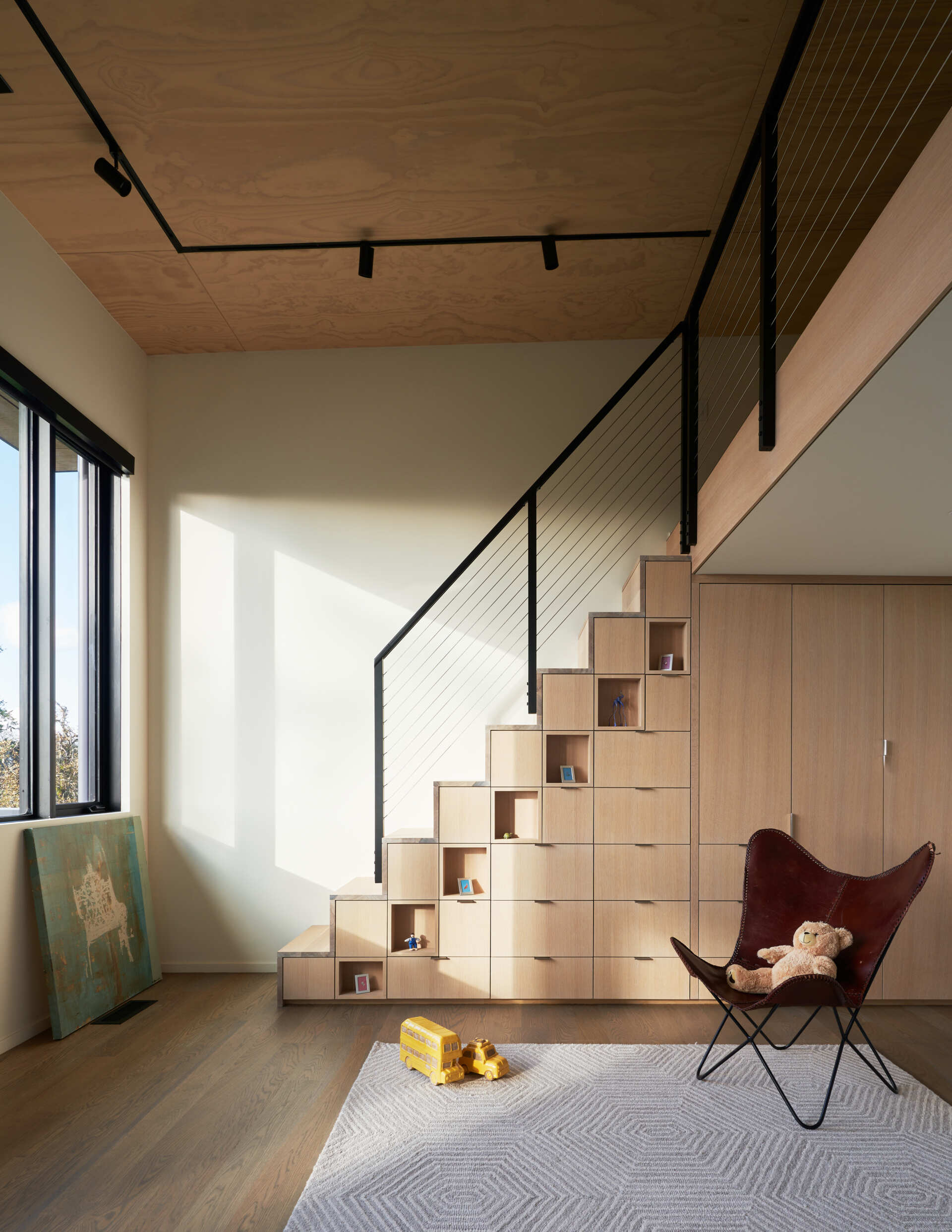 A modern play room with storage built-in underneath the stairs.