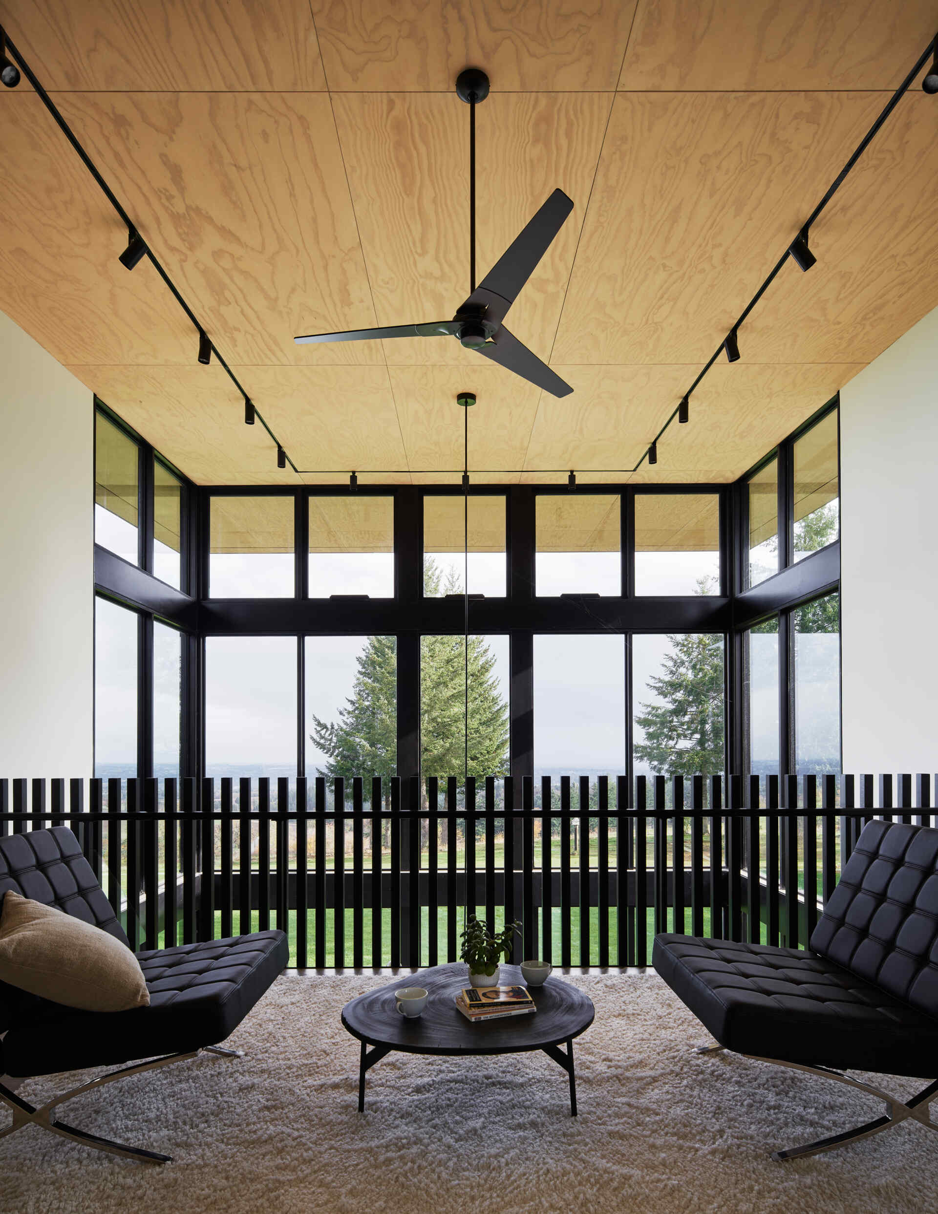 A modern loft area with seating and views of the lower level below.