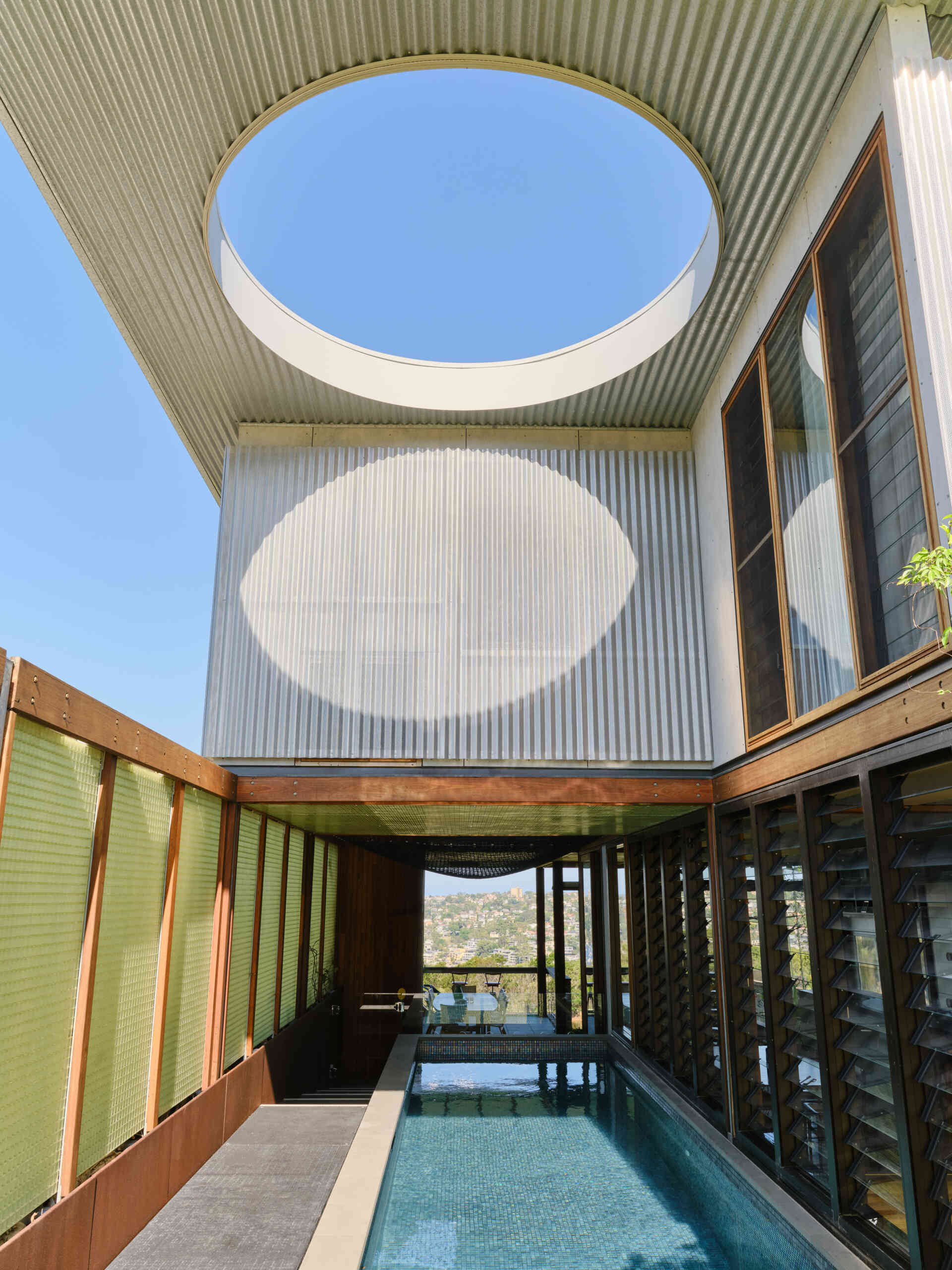 This raised lap pool stretches alongside the home, reflecting light indoors and creating a dramatic architectural centrepiece.