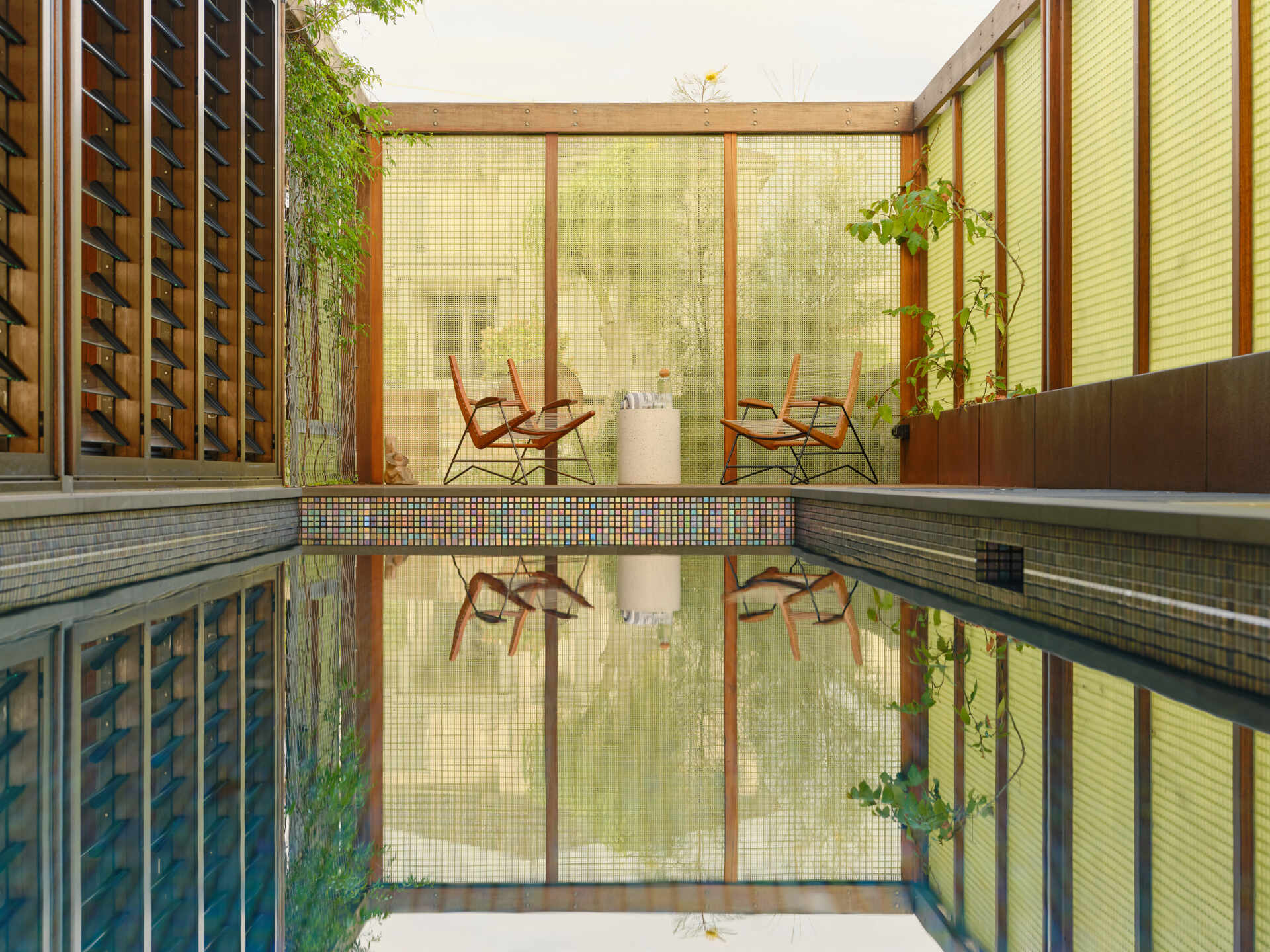 This raised lap pool stretches alongside the home, reflecting light indoors and creating a dramatic architectural centrepiece.