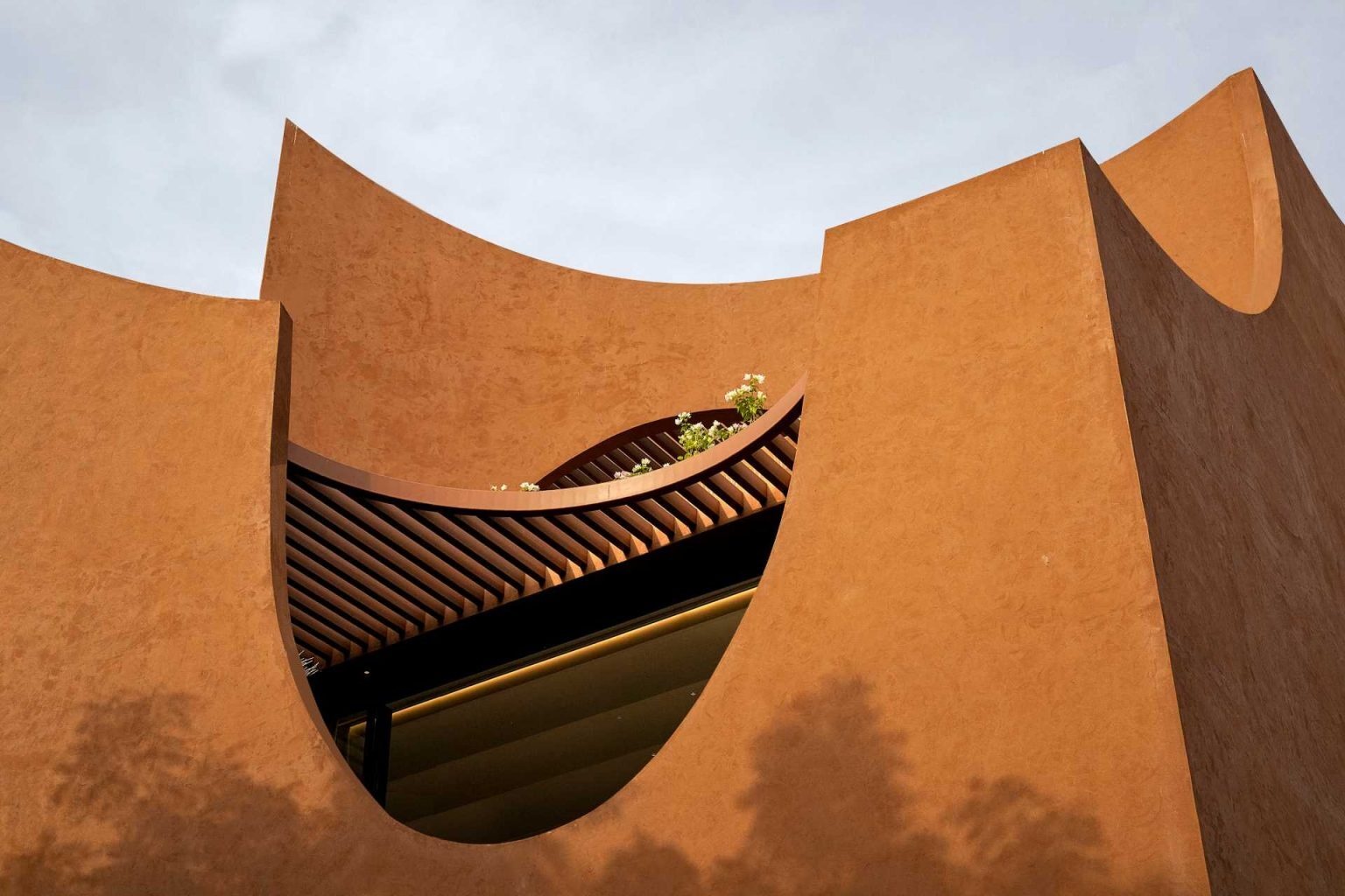 Flowing curves and layered arches wrap around this Rajasthan home, creating shaded outdoor spaces that help reduce heat gain during the region’s extreme summers.