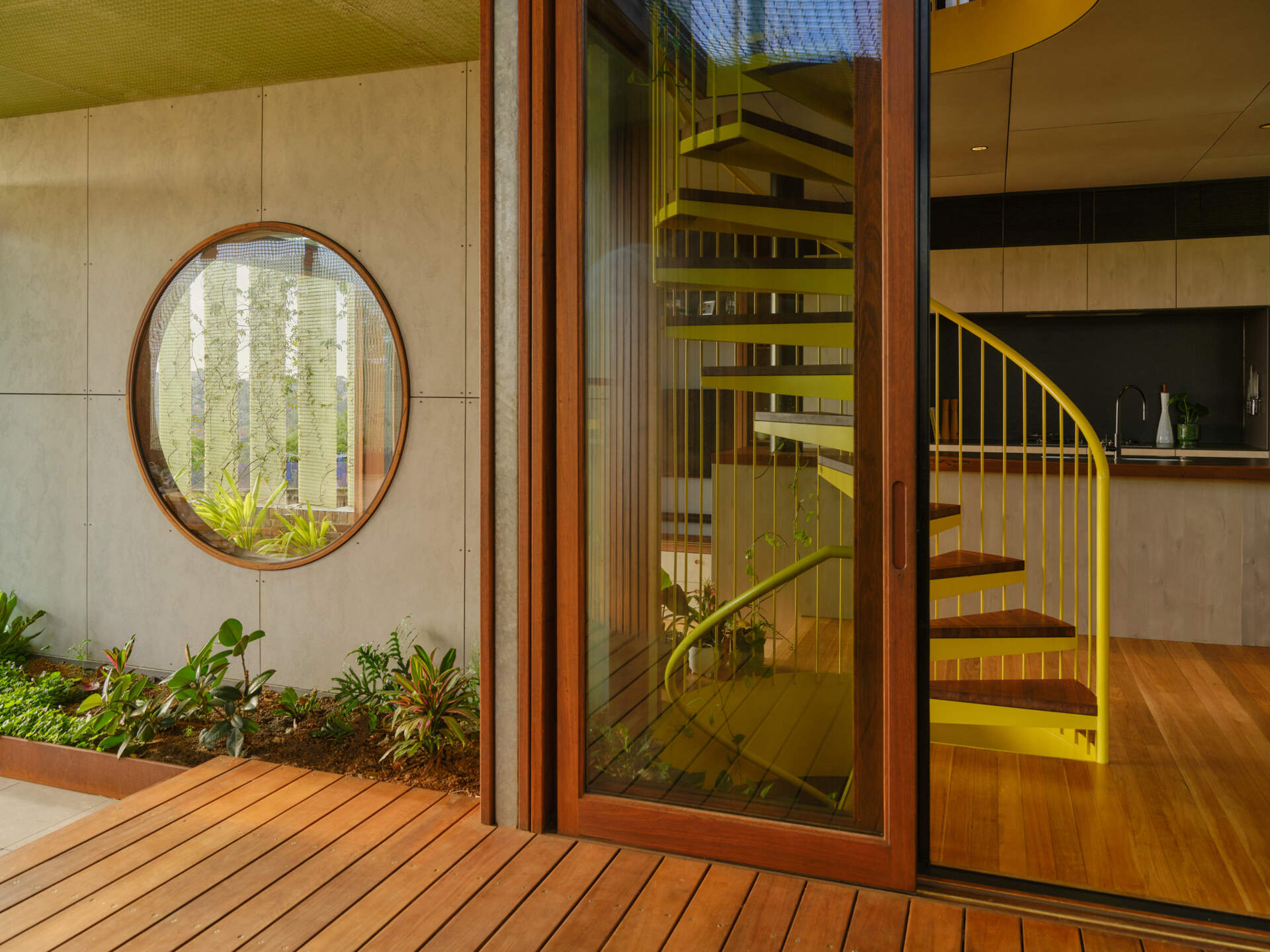 A bold yellow spiral staircase winds through three levels, becoming one of the most striking features of the entire home.