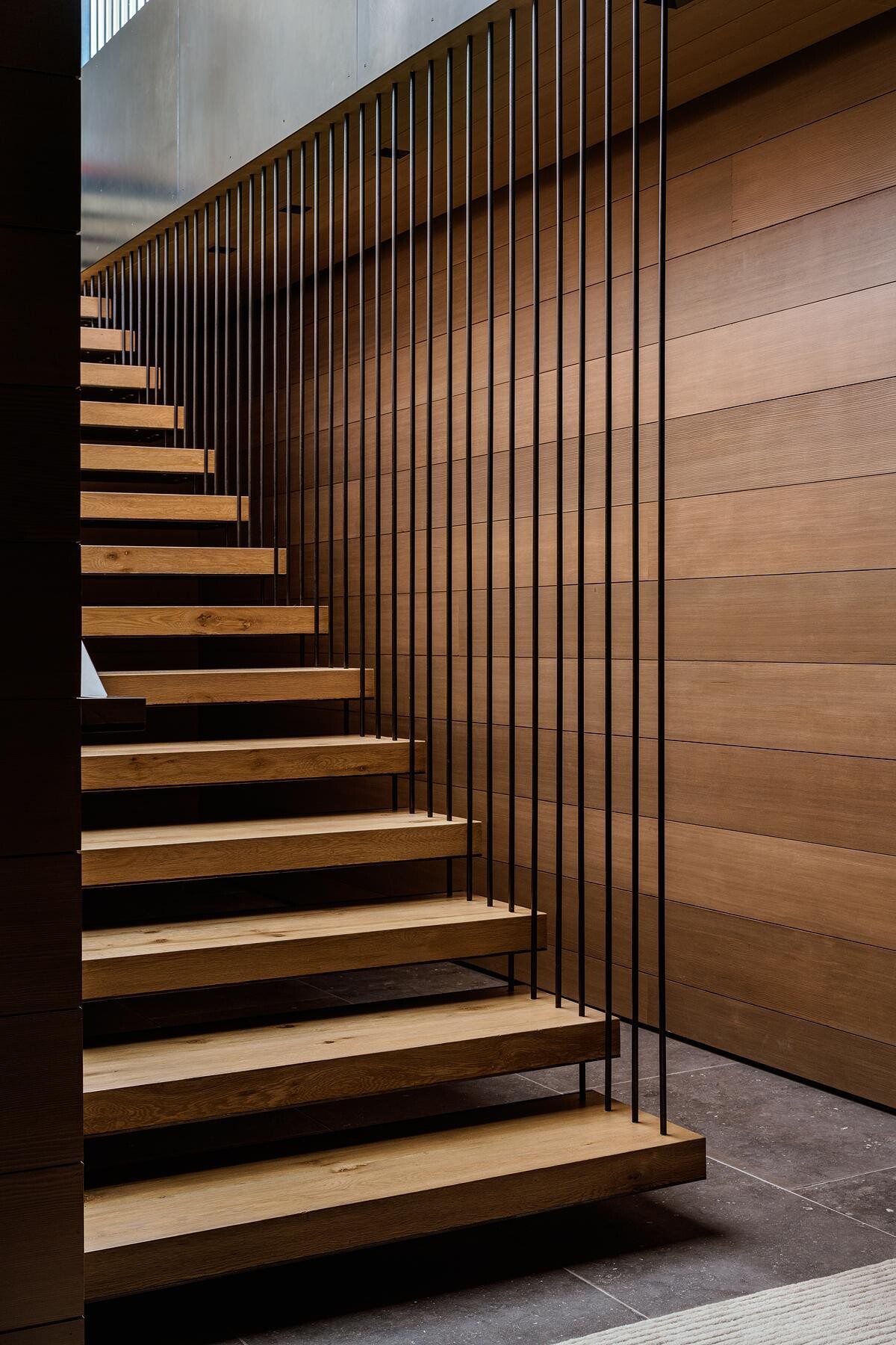 Architectural stairways and circulation spaces showcase exposed steel and timber while guiding movement through the home's split-level design and changing hillside views.