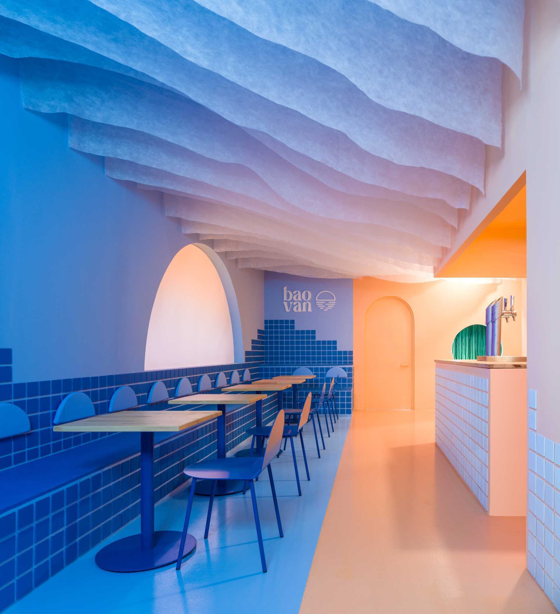 A dramatic half-moon screen programmed by Vitamin Studio recreates the changing colors of a sunset throughout dinner service. The immersive lighting installation turns Baovan into a restaurant where the atmosphere evolves as guests dine.
