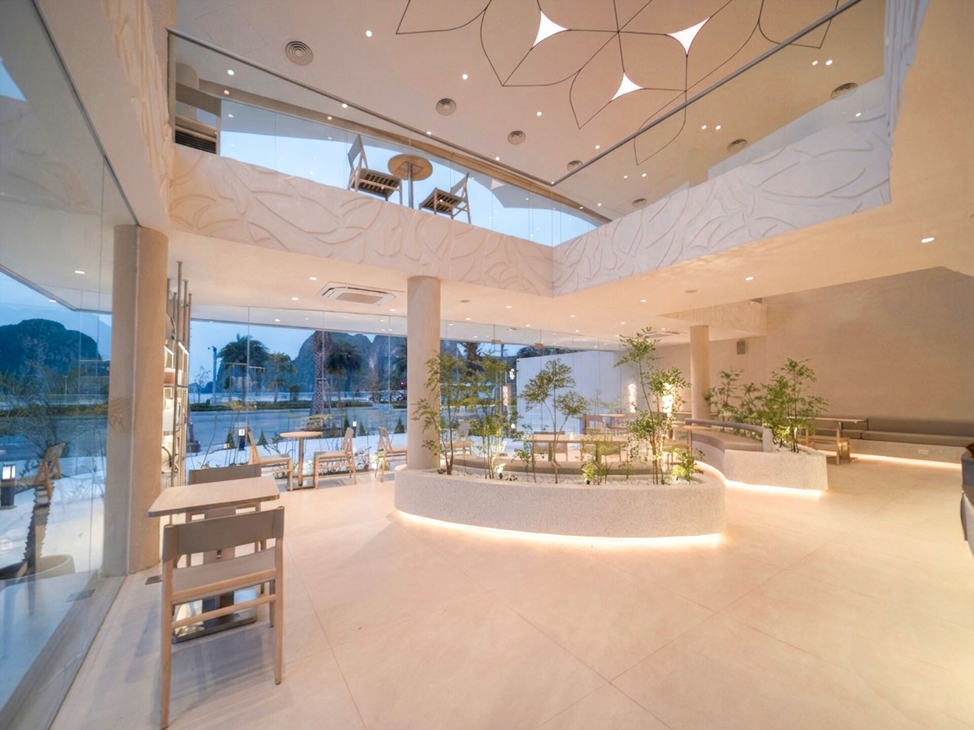Inspired by the shape of a boat and featuring sweeping curved glass, soft flowing ceilings, and a calming neutral interior, this contemporary tea house celebrates one of Vietnam's most spectacular natural landscapes through architecture.