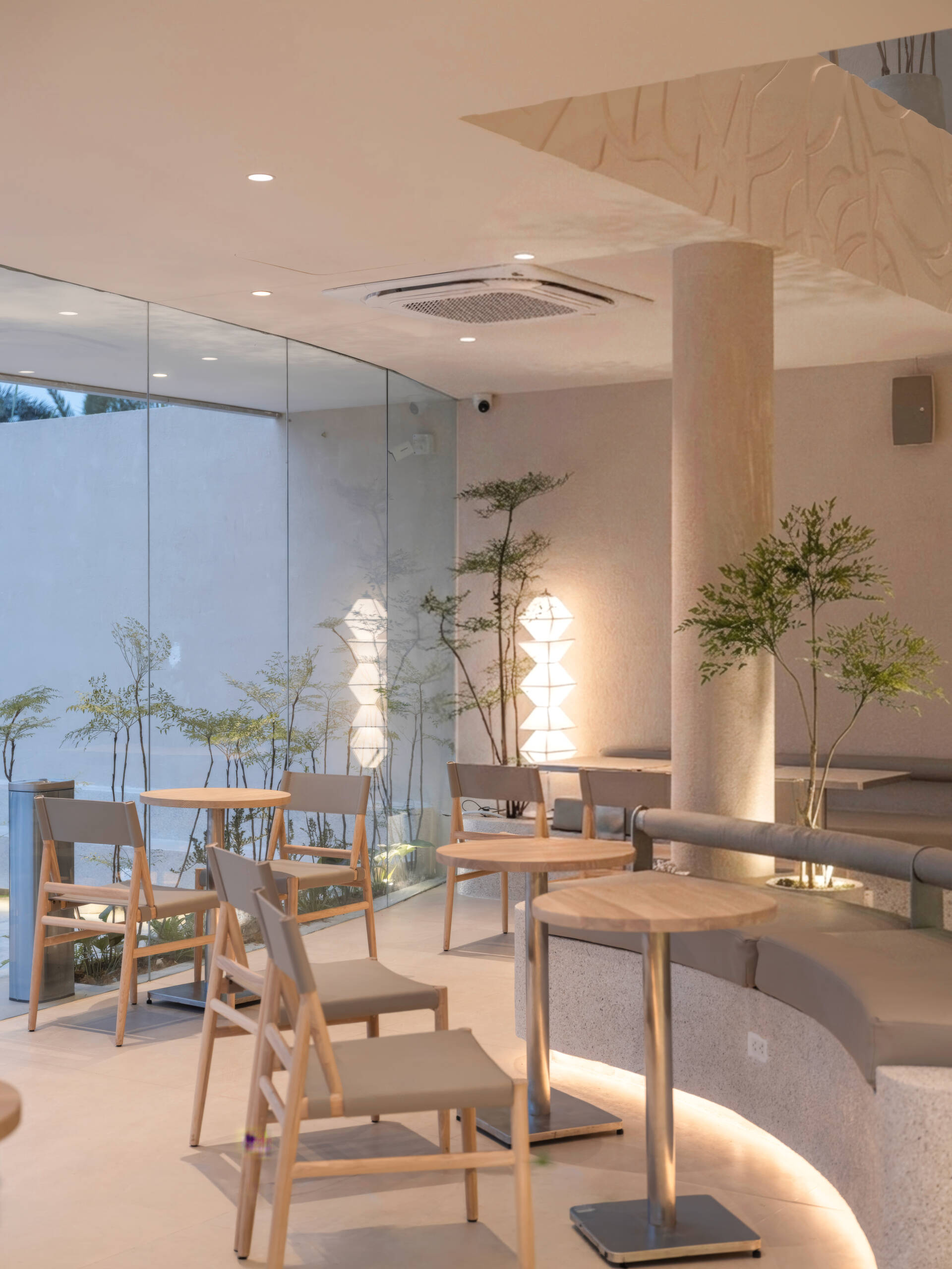 Inspired by the shape of a boat and featuring sweeping curved glass, soft flowing ceilings, and a calming neutral interior, this contemporary tea house celebrates one of Vietnam's most spectacular natural landscapes through architecture.