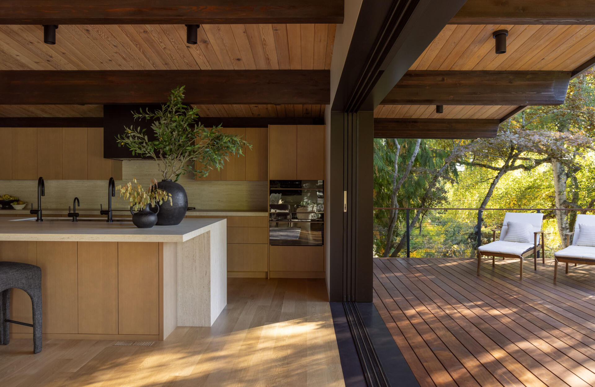See how Island Crest's open kitchen, dining area, and expanded deck create flexible spaces for entertaining. White oak finishes, Dekton countertops, and an 18-foot sliding glass door blur the line between indoors and out.