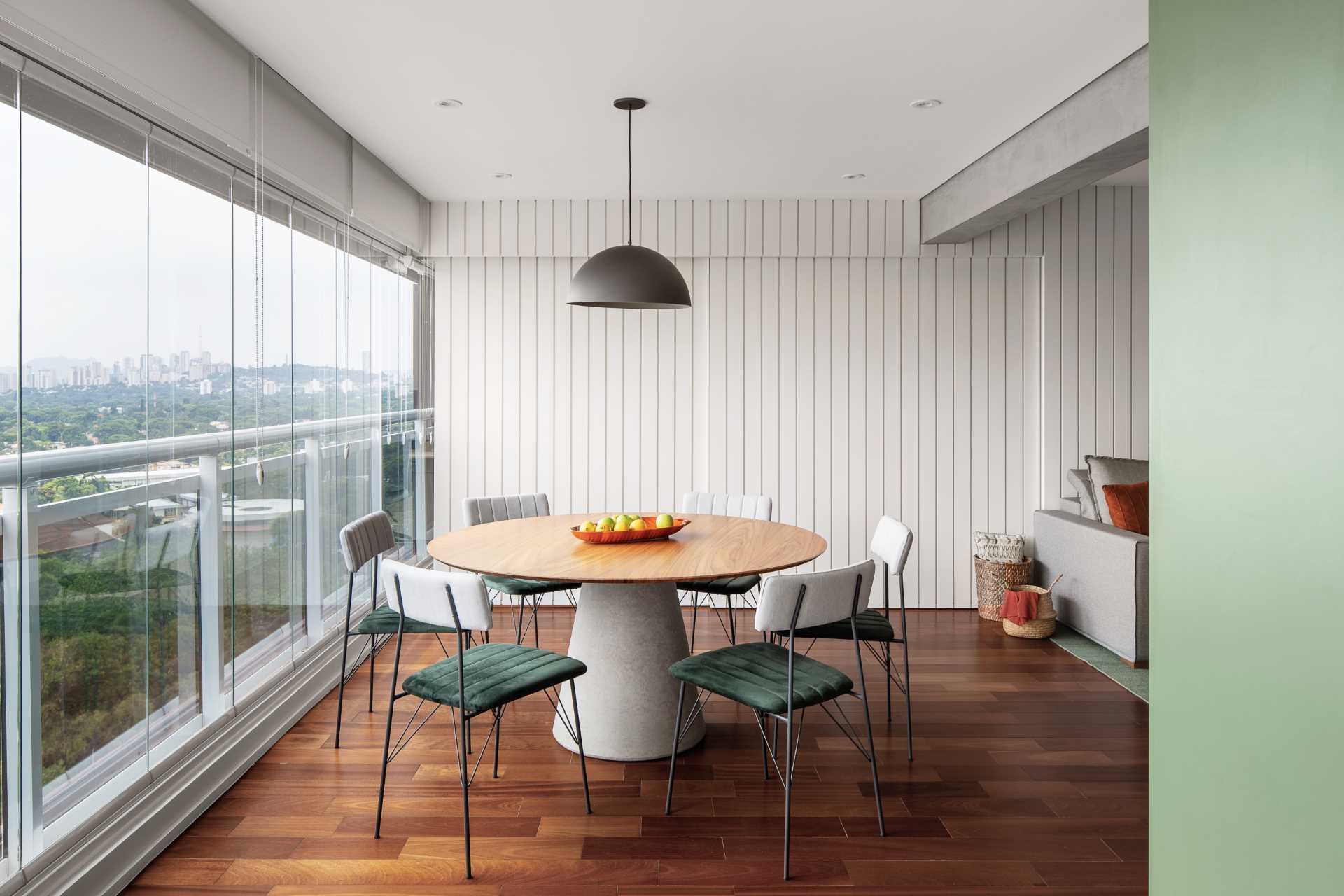 Discover how a striking white feature wall transforms this São Paulo apartment, hiding a home office and kitchen behind sleek sliding pocket doors while maintaining a clean, modern look.