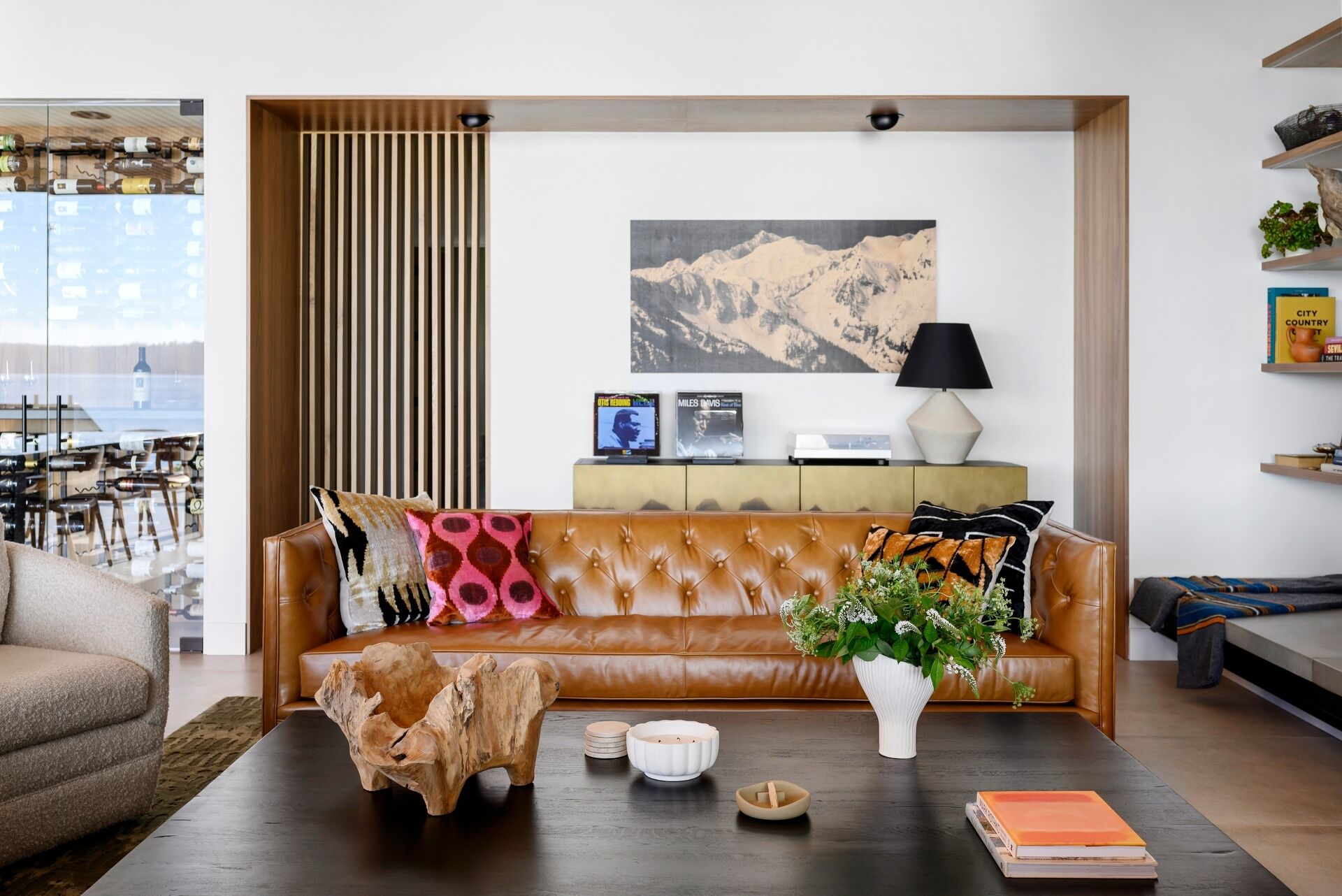 Explore the warm and inviting living room at Lantern House, where a statement fireplace, timber ceiling, and floor-to-ceiling glazing create the perfect place to gather.