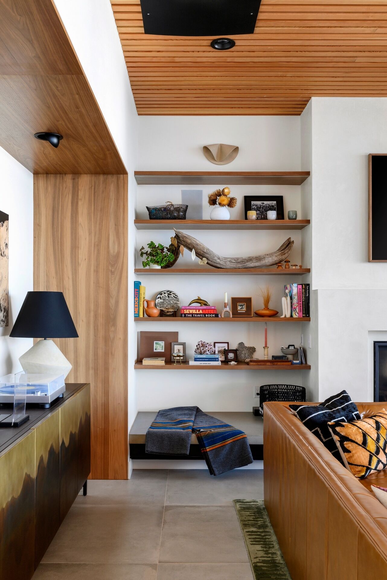 Explore the warm and inviting living room at Lantern House, where a statement fireplace, timber ceiling, and floor-to-ceiling glazing create the perfect place to gather.