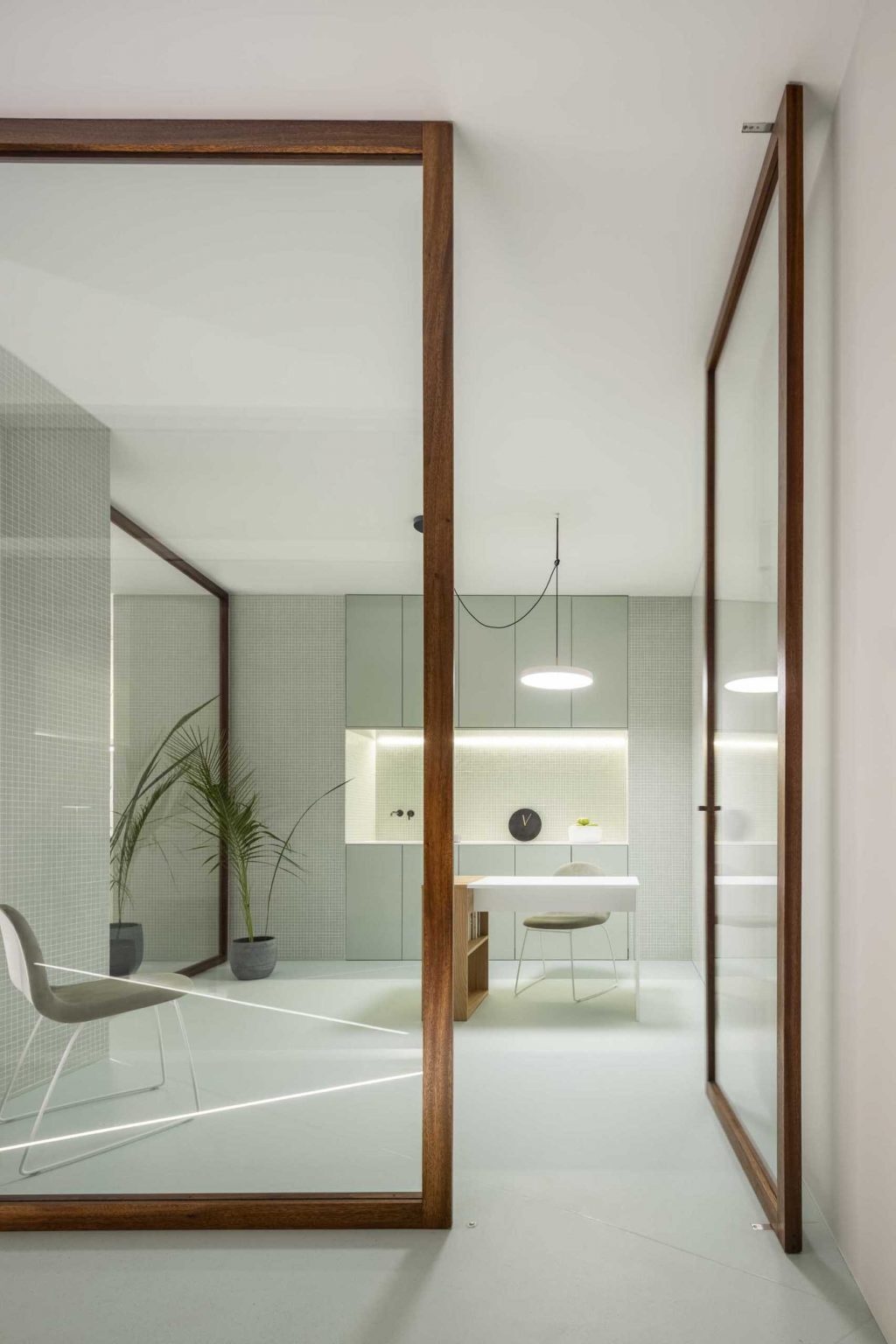 Wood-framed glass partitions keep the clinic bright and open while allowing natural light to reach every corner of the interior.