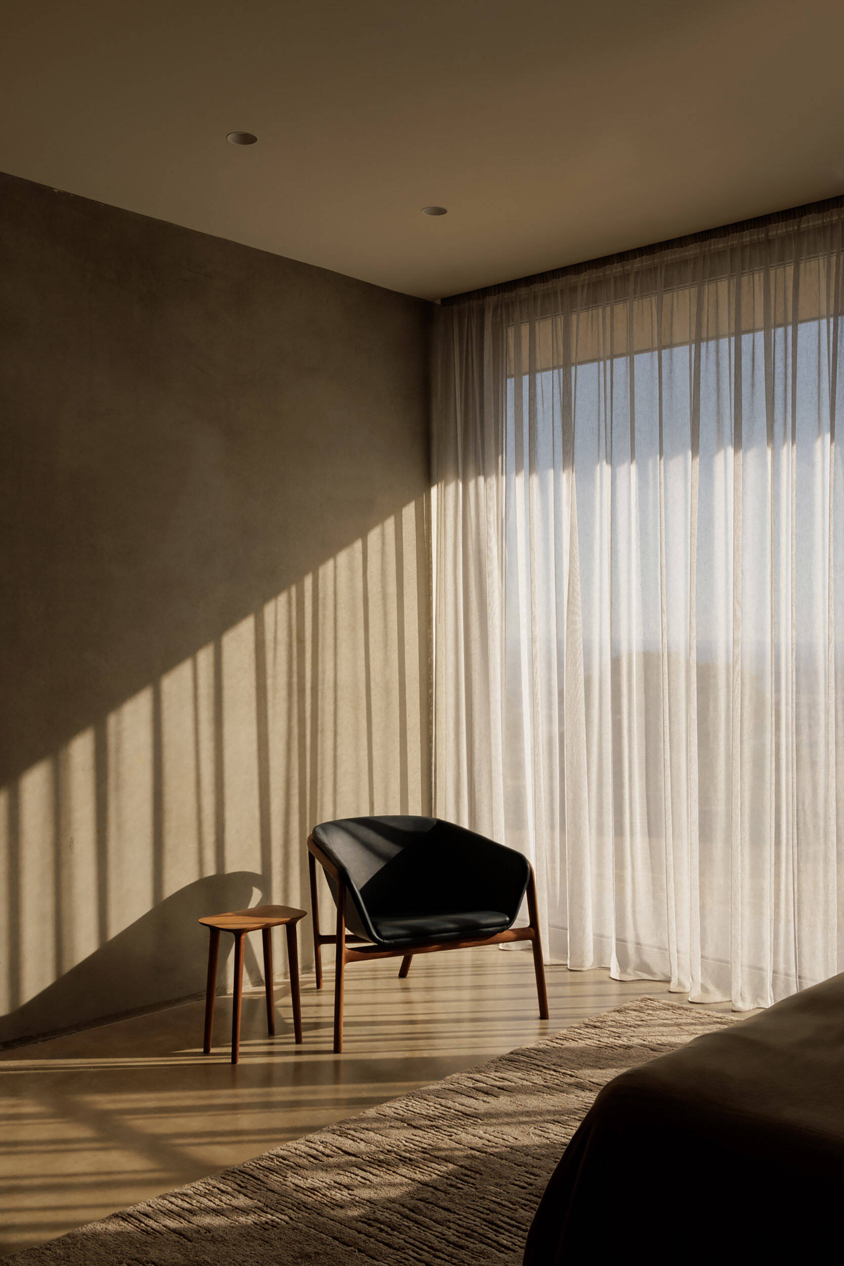 The bedroom is oriented toward the surrounding scenery, allowing the dramatic views to become a defining feature of the space. Large openings bring natural light deep into the room while maintaining a strong visual connection to the landscape.
