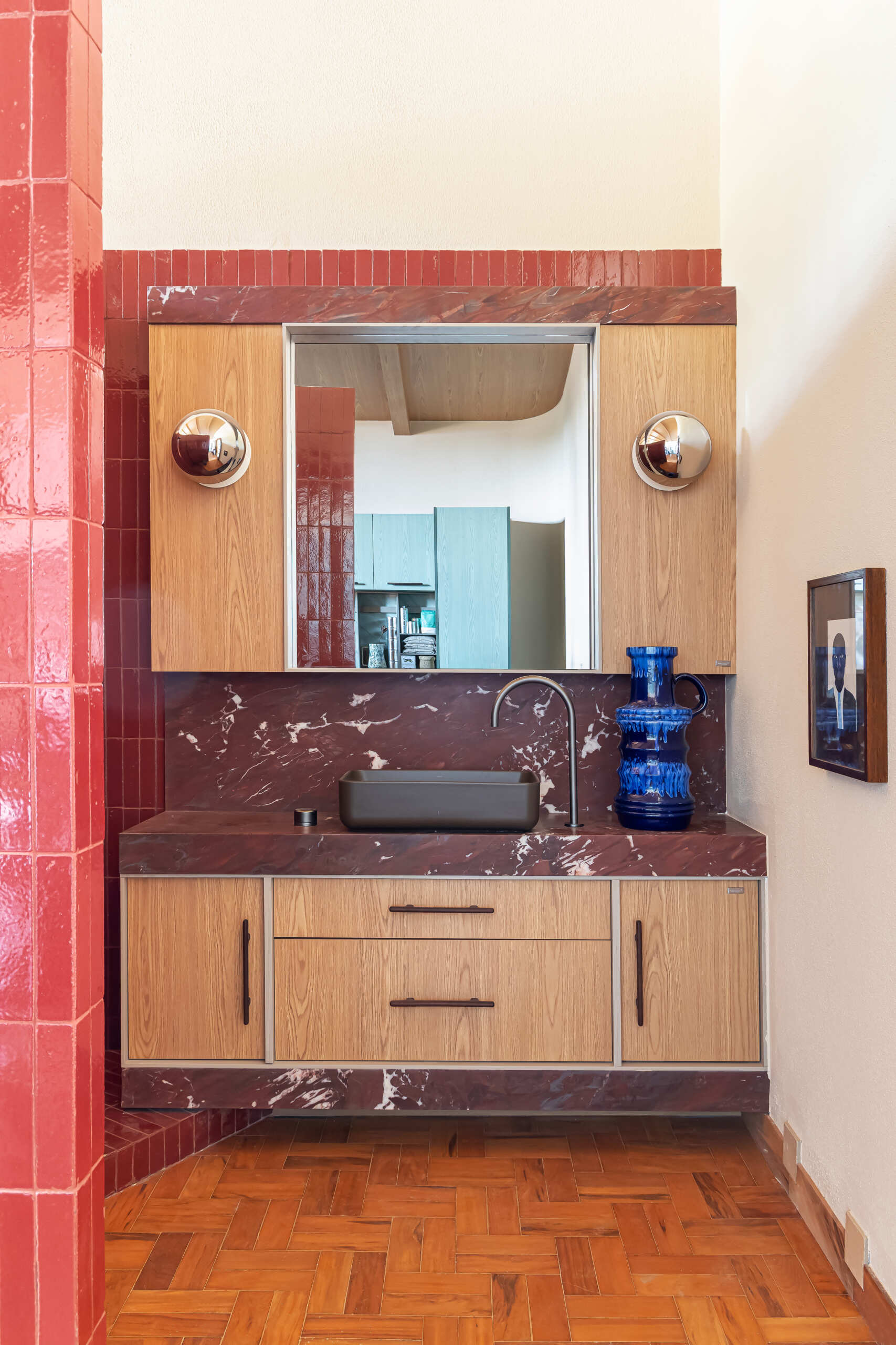 Red walls and ceilings, Bordeaux marble, and curved geometry create a bold bathroom design hidden inside the studio's iconic cylinder.