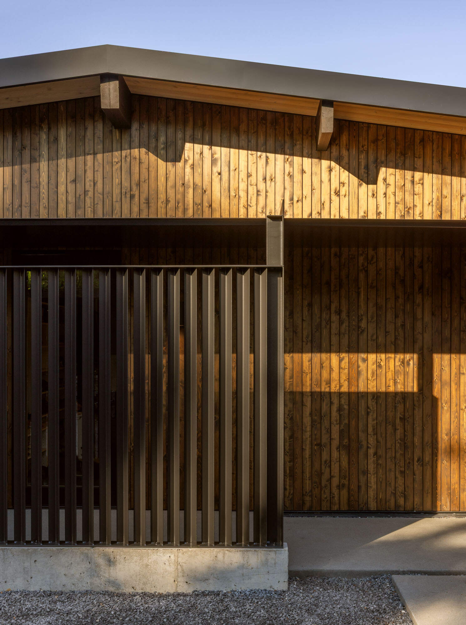 Discover the exterior details that give Island Crest its warm midcentury character, from natural timber cladding to crisp black steel accents that create a welcoming first impression.