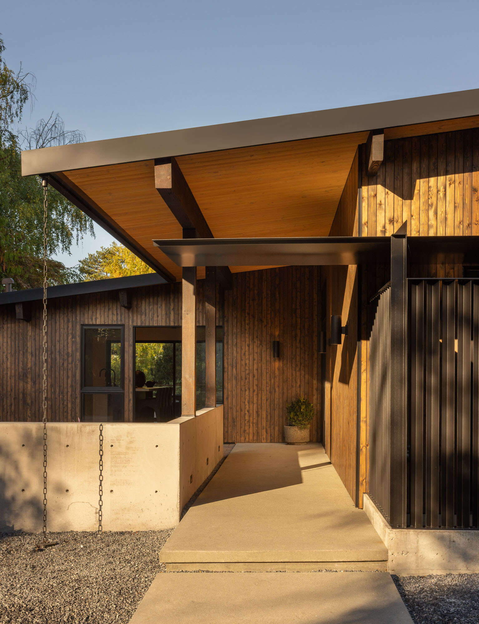 Discover the exterior details that give Island Crest its warm midcentury character, from natural timber cladding to crisp black steel accents that create a welcoming first impression.